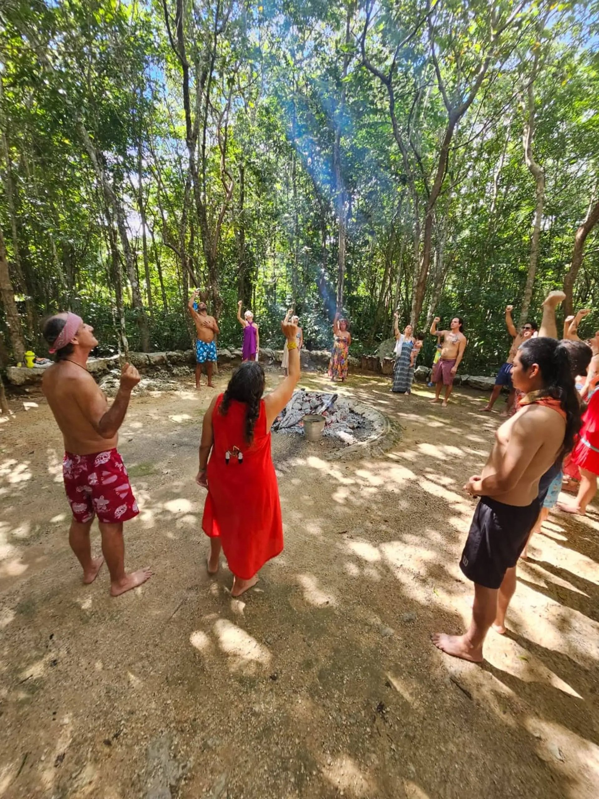 Un grupo se reúne alrededor de un fuego ceremonial en la selva maya para un ritual espiritual de temazcal