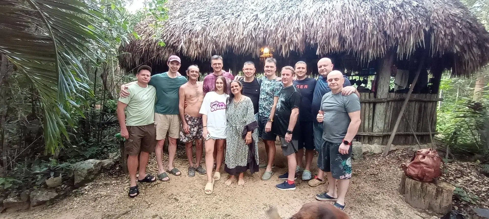 un grupo de turistas posa frente a una palapa en la selva muy contentos despues de su temazcal