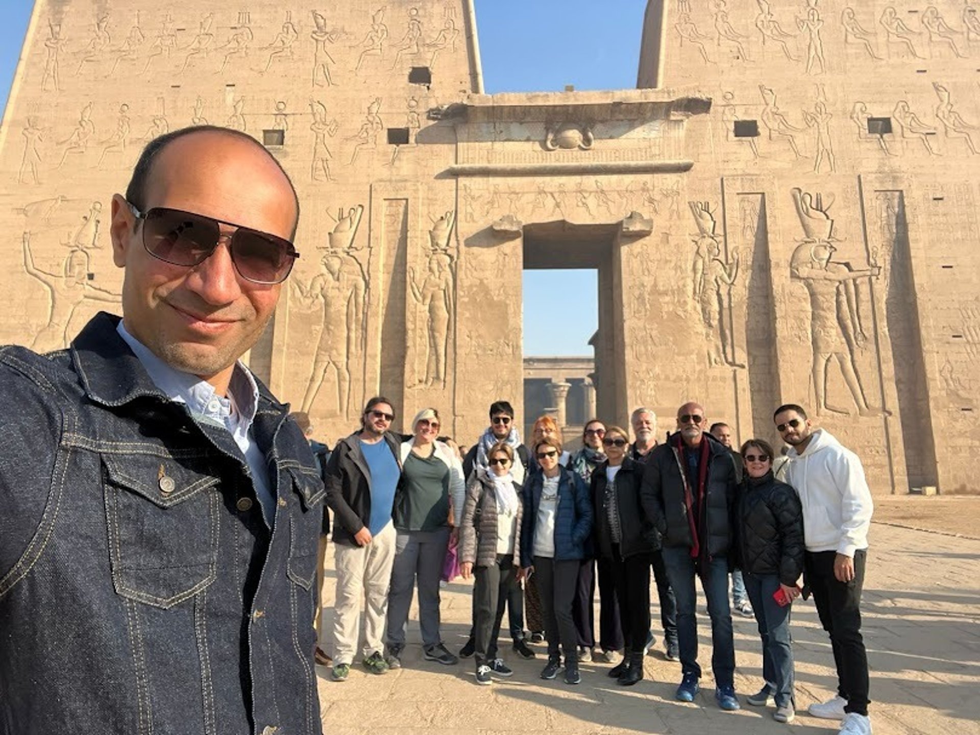 GRUPO DE TURISTAS DO BRASIL VISITANDO O EGITO COM GUIA EGIPTOLOGO HADI , FOTO TIRADA FRENTE DO TEMPLO DE EDFU