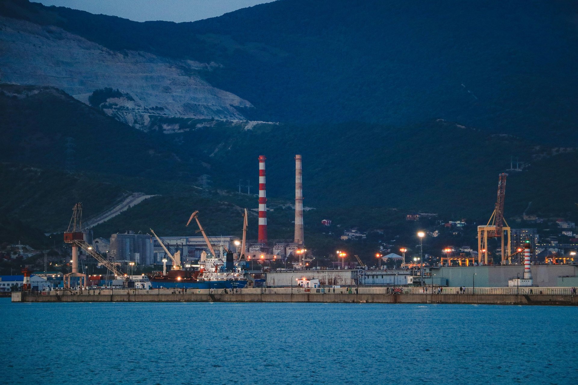 a person lying on a bed with another man standing behind him