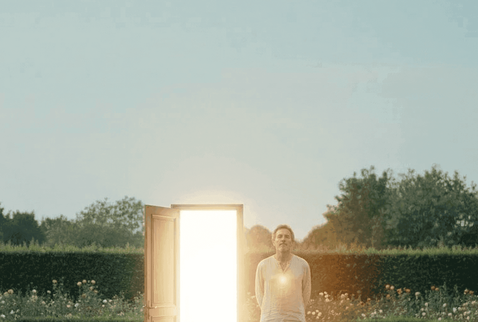 a woman in a white veil standing in front of a hedge