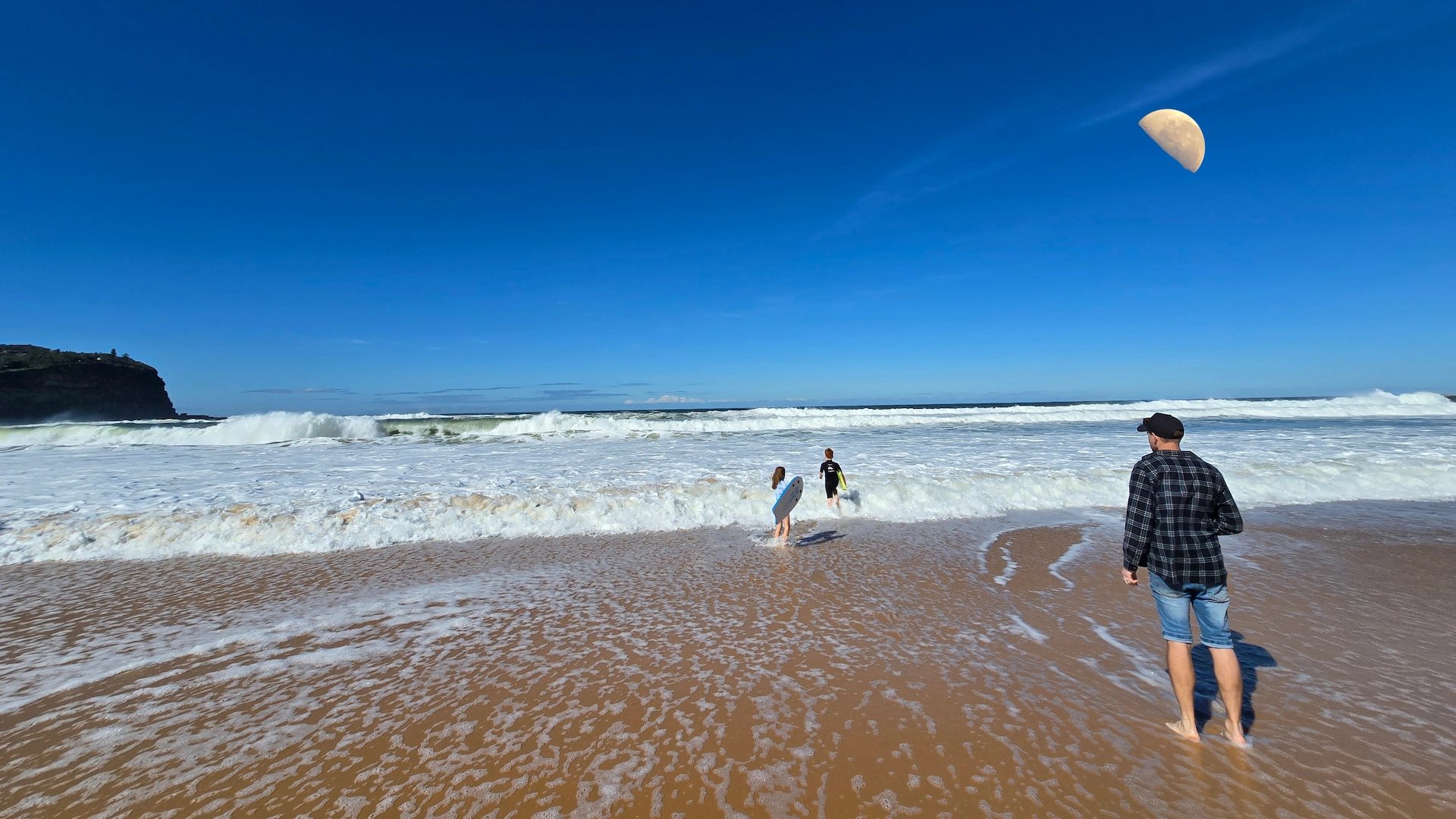 Family on shoreline—waves, sand, and peaceful sky. A reflection of Holy Fusion’s purpose