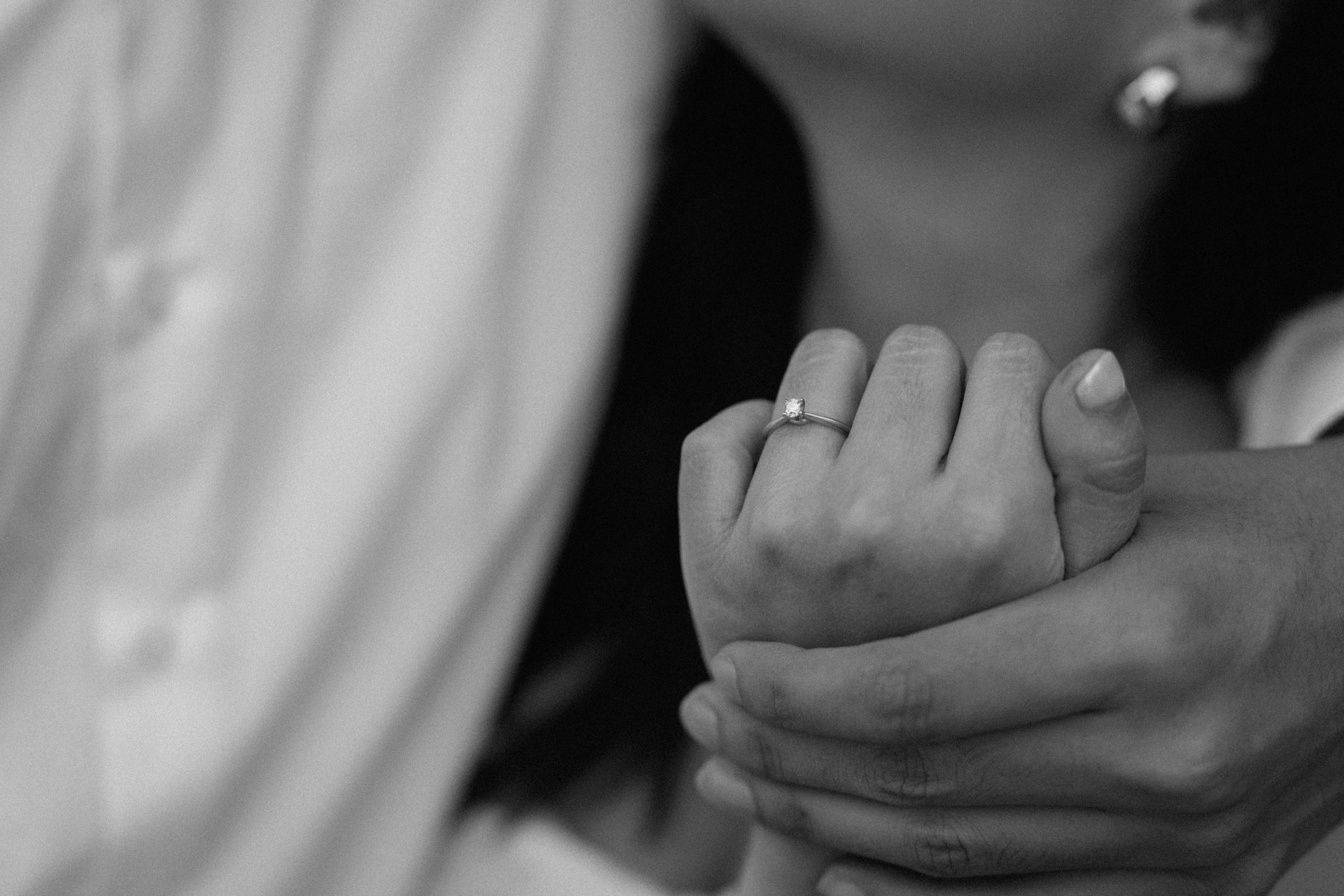 two person holding hands on white flower