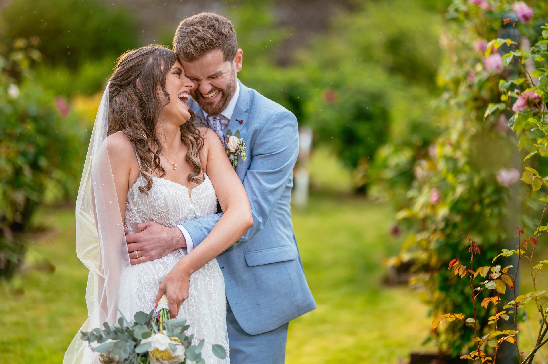 Couple laughing in gardens at Tall John’s House Brecon Beacons, romantic and natural wedding photo