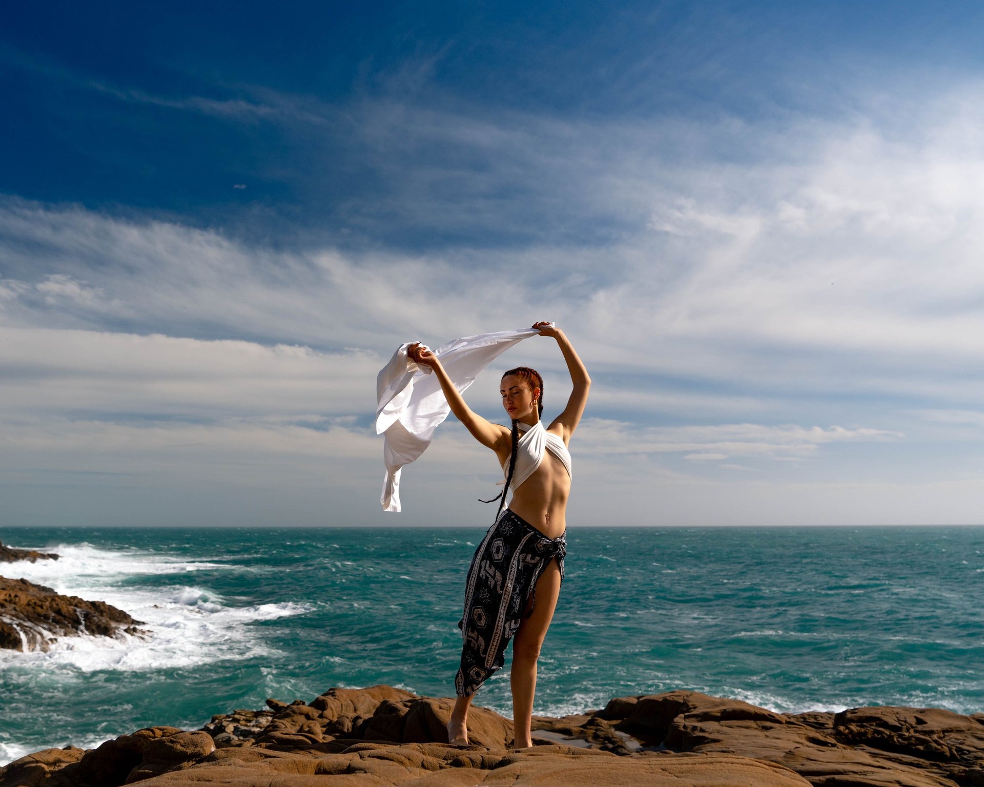 woman wearing yellow long-sleeved dress under white clouds and blue sky during daytime
