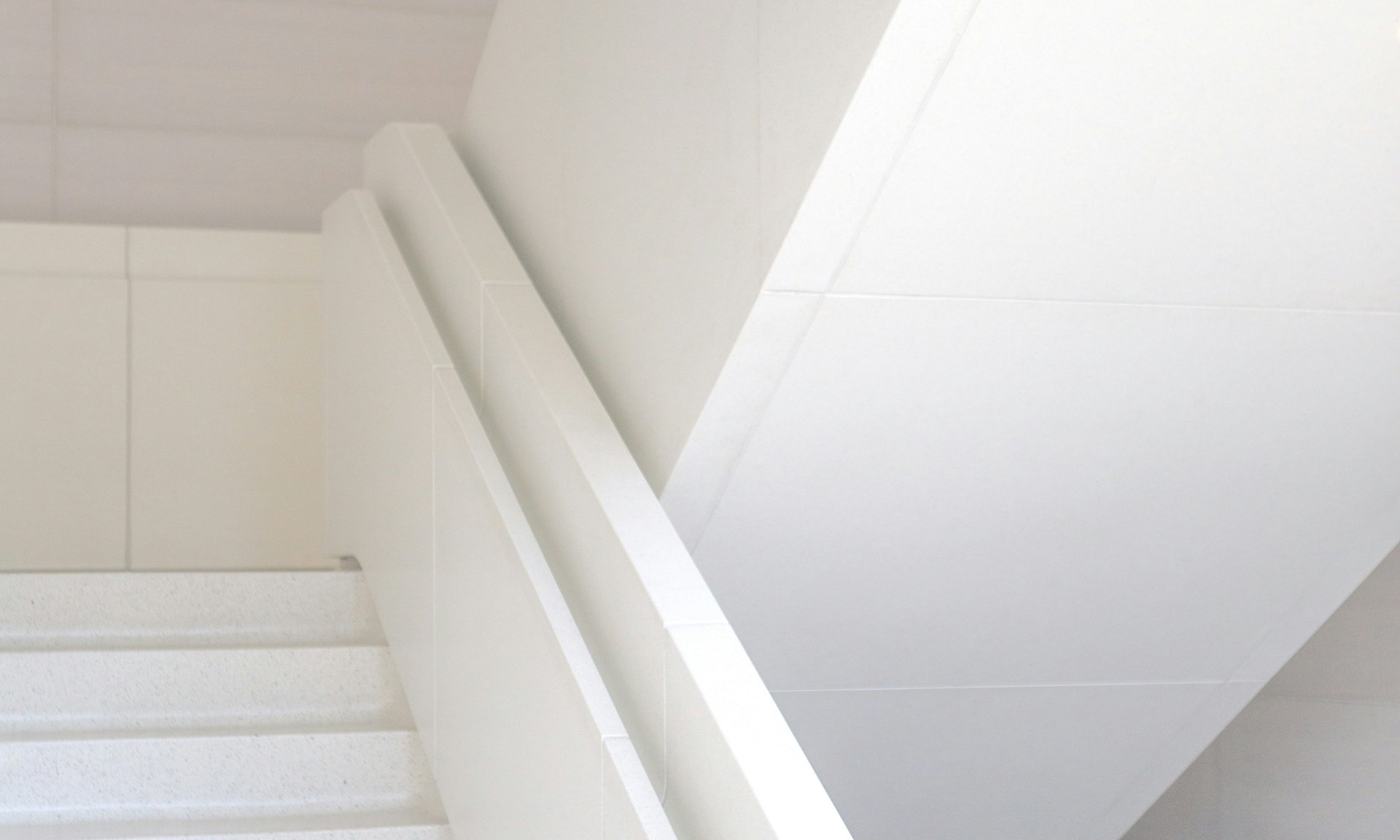 an abstract photo of a curved building with a blue sky in the background