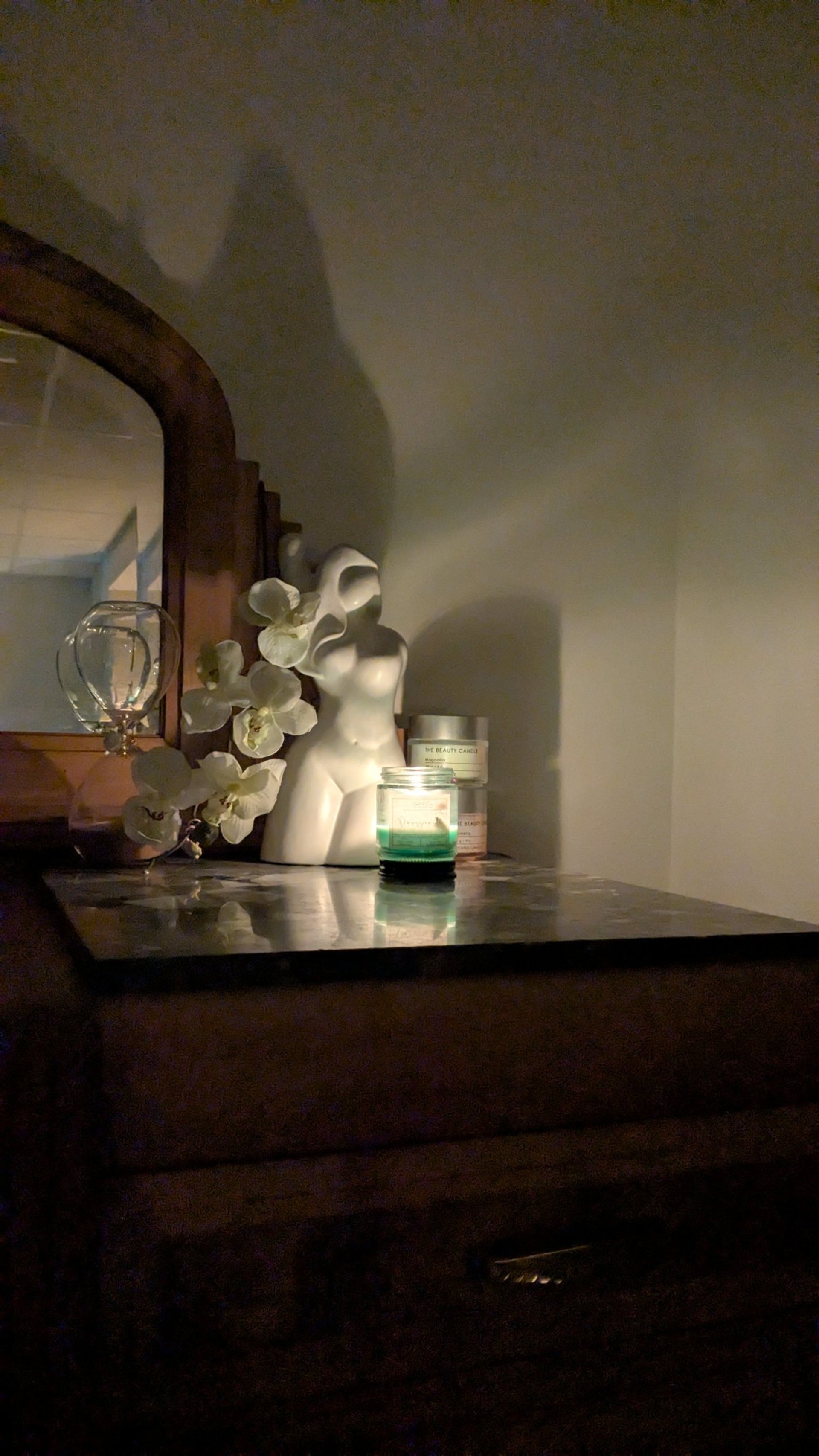 An open empty notebook on a white desk next to an iPhone and a MacBook