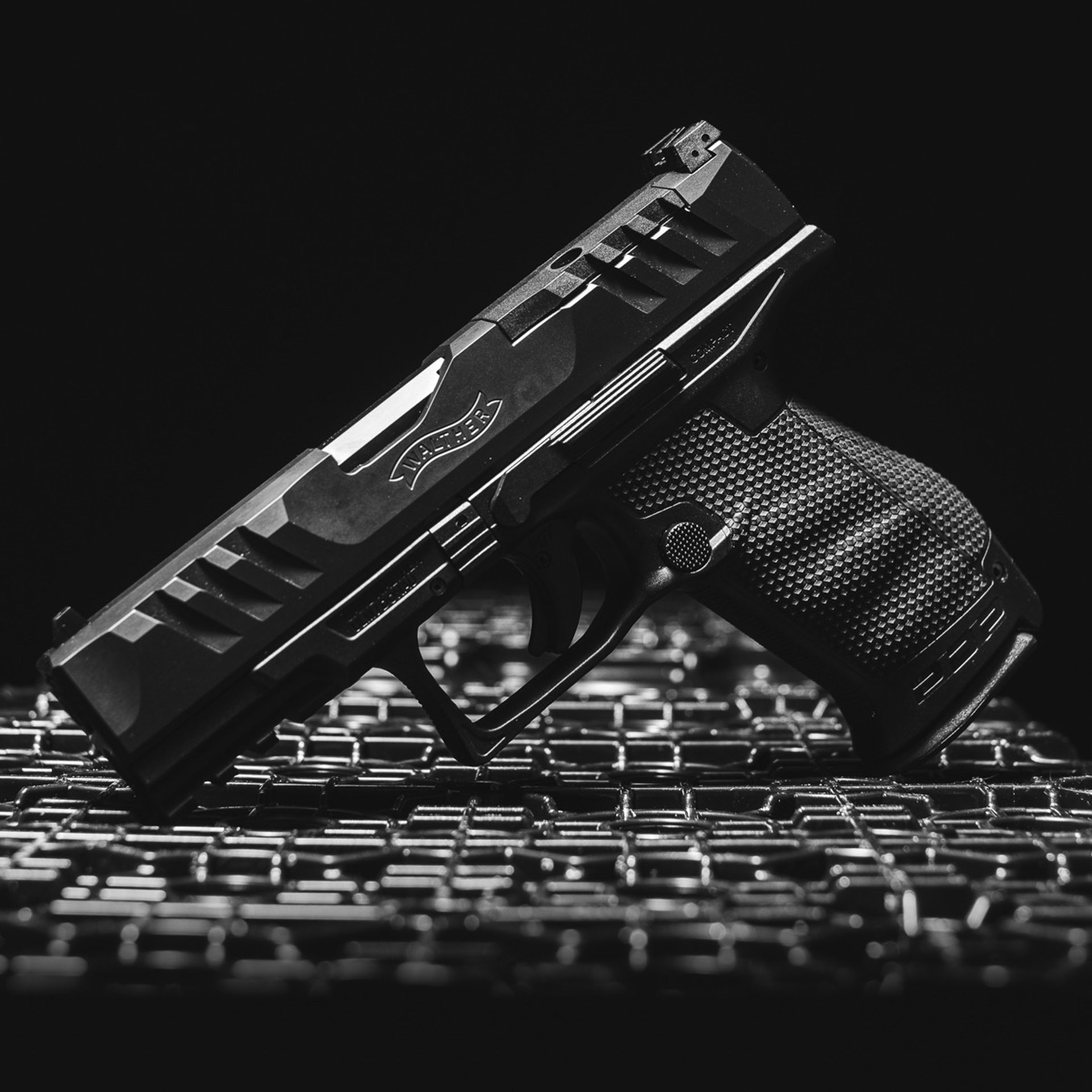 a black gun with gold accents on a black background