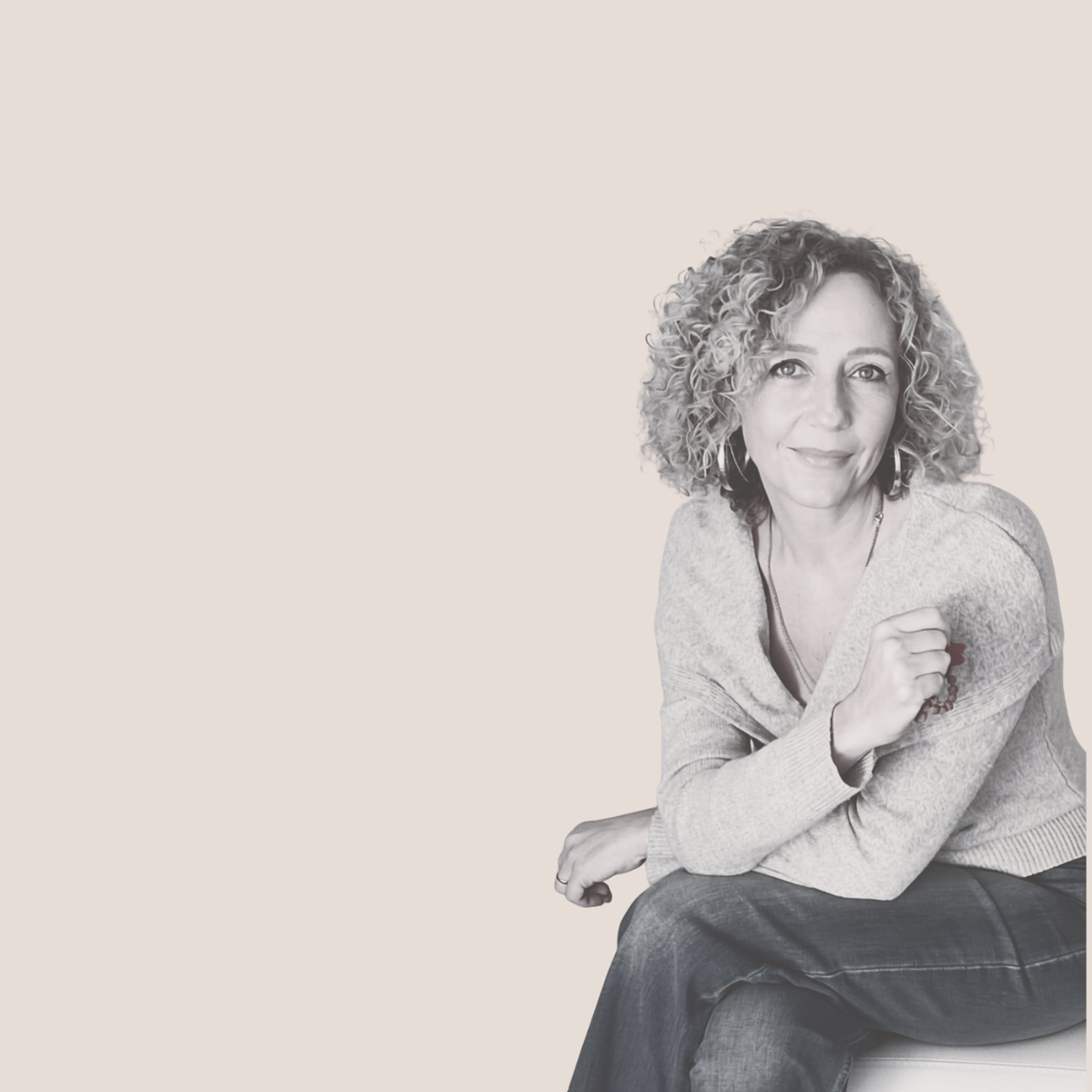 A woman with red curly hair sitting on a dock.