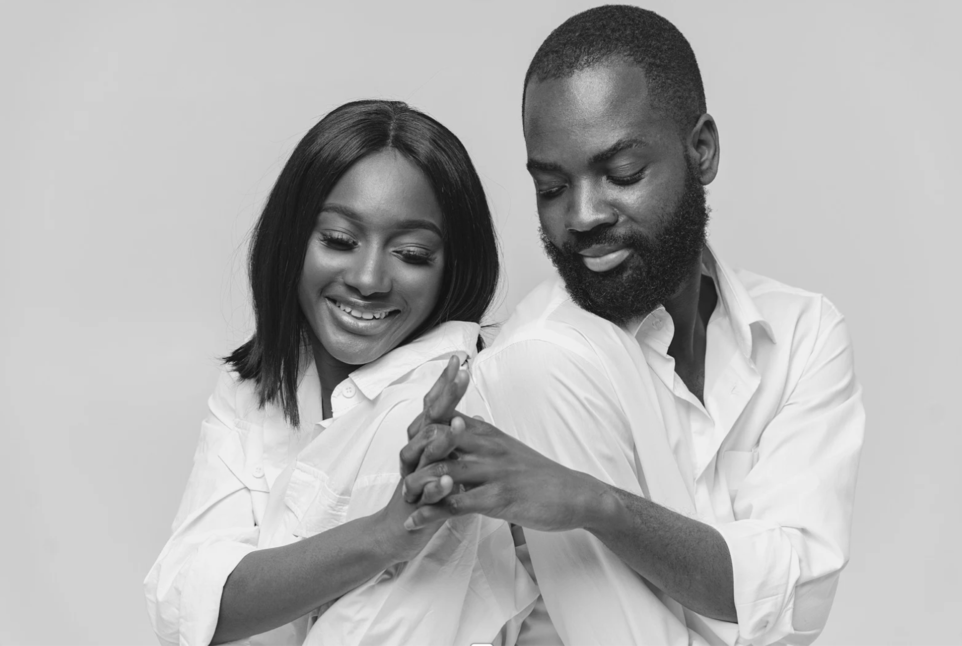woman in white sweater holding black round frame