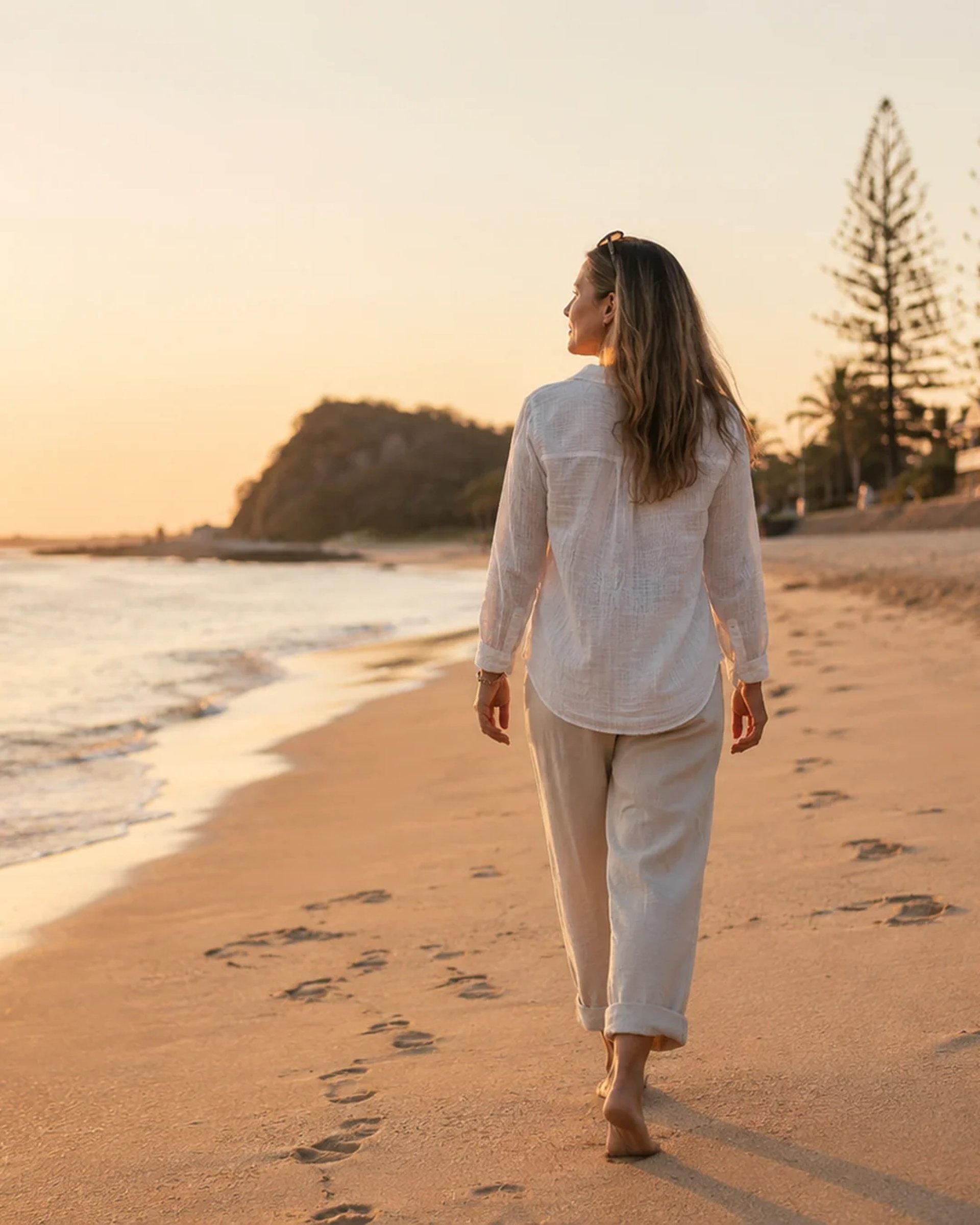 woman in black and white floral dress standing on seashore during daytime