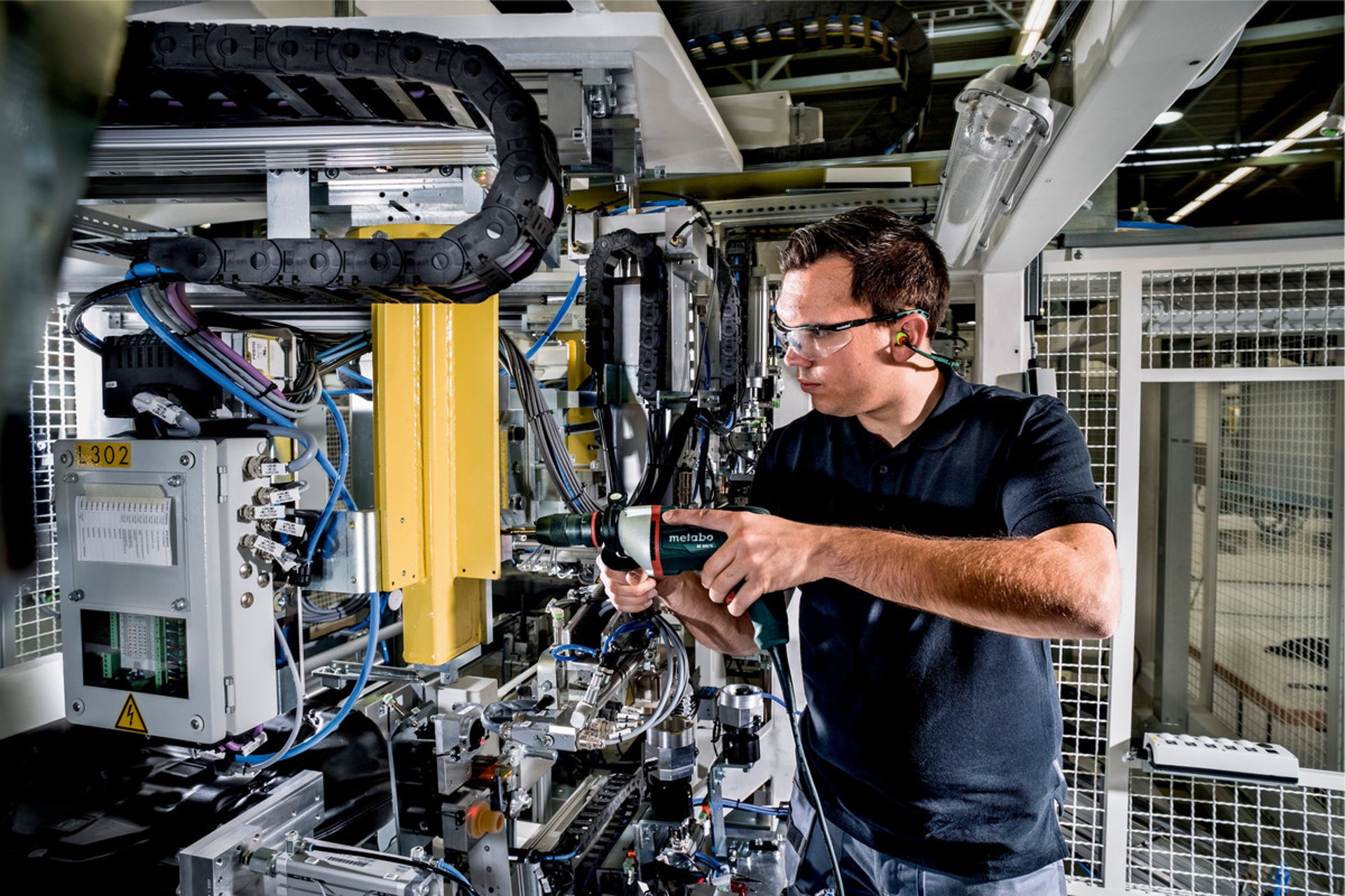 uomo che usa un trapano di marca metabo