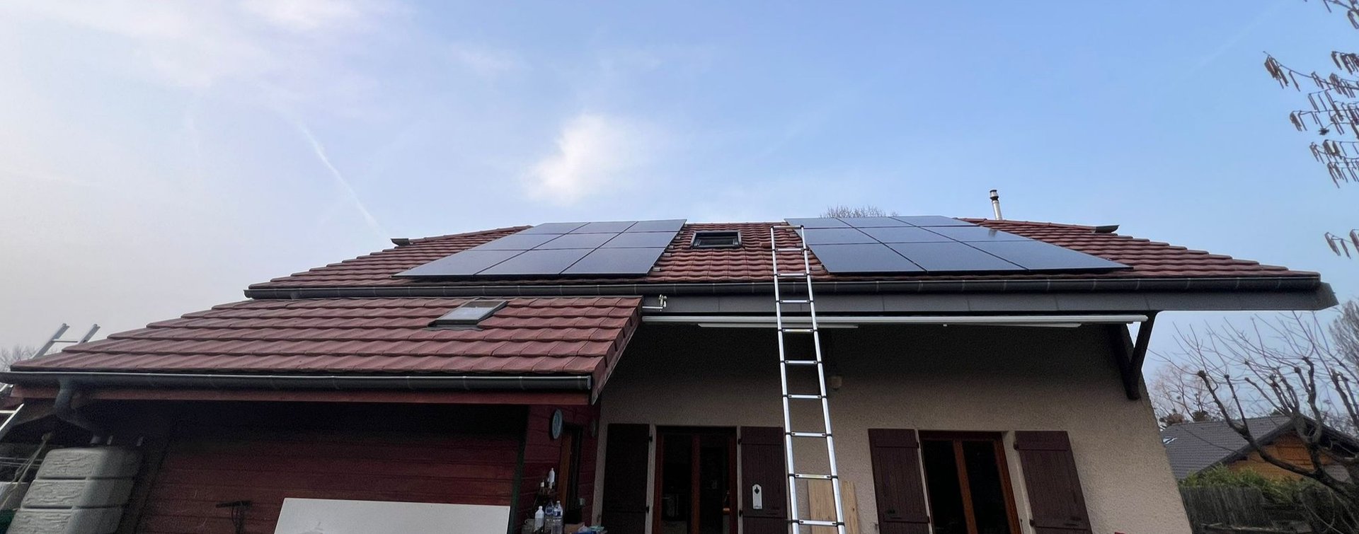 installation solaire 9 kWc sur toiture pentue avec panneaux photovoltaïques autour d'un Velux face au lac Léman