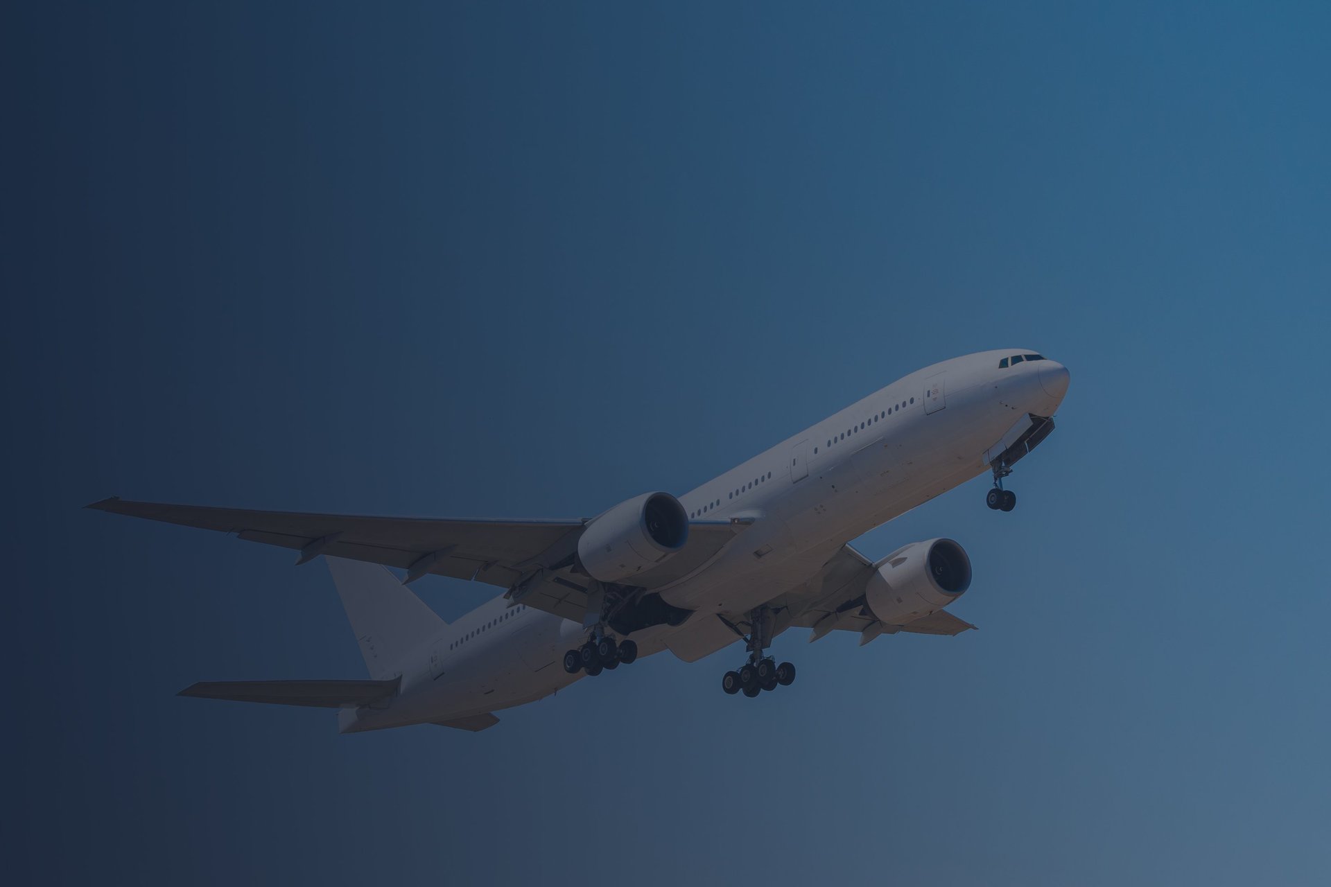 a large jetliner flying through a cloudy blue sky