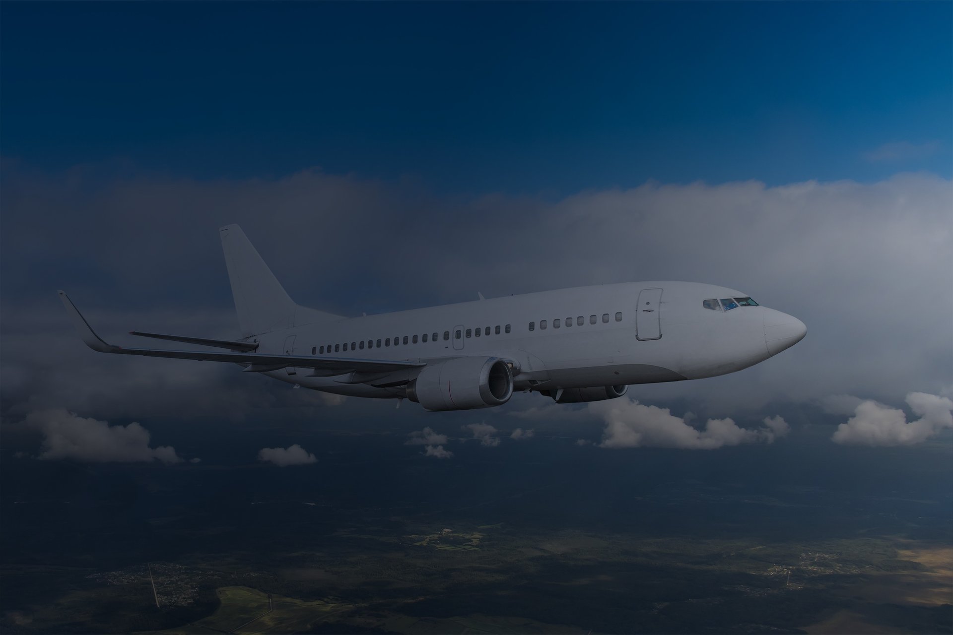 a large jetliner flying through a cloudy blue sky