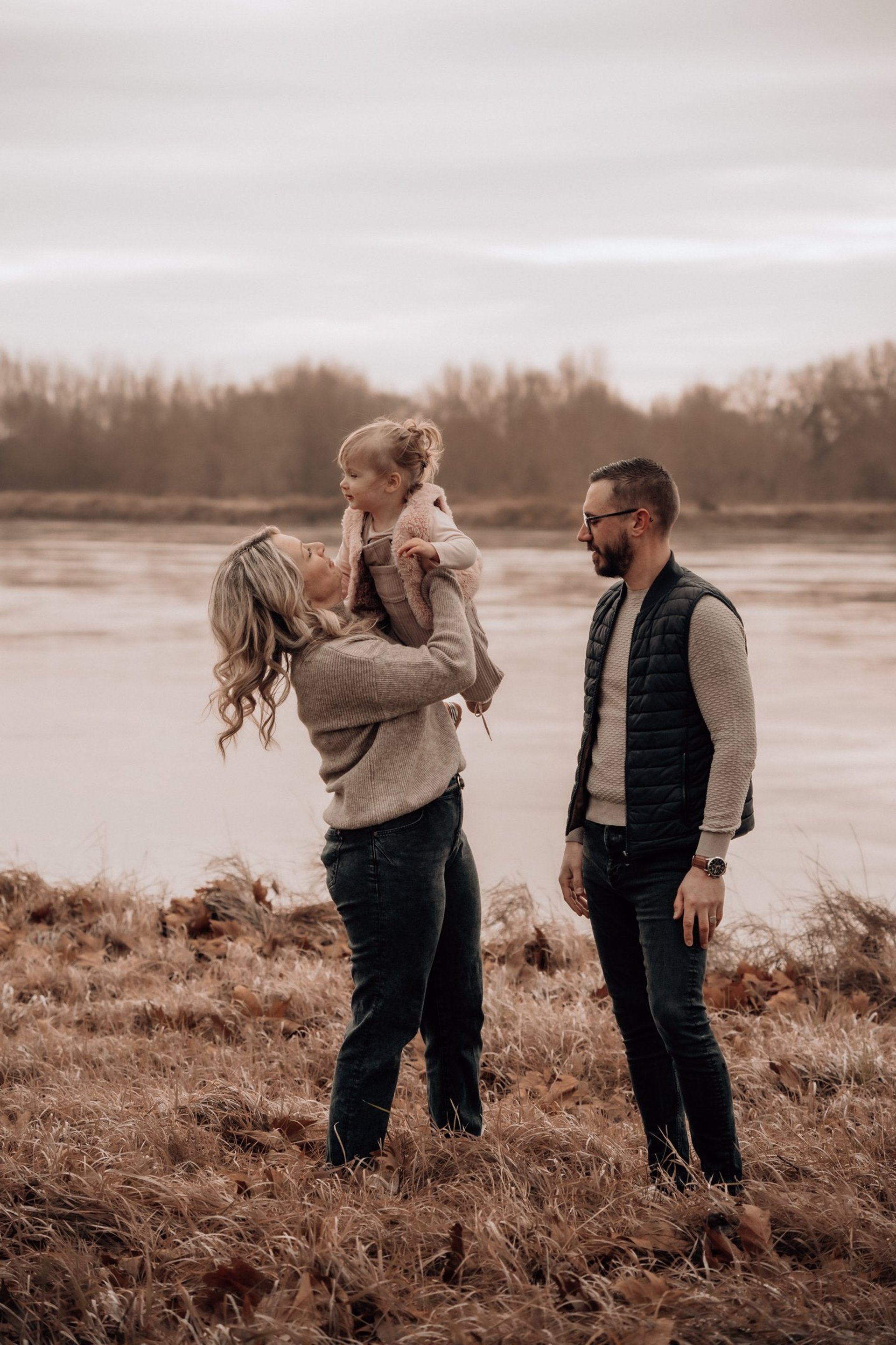 man in gray shirt carrying baby in grayscale photography