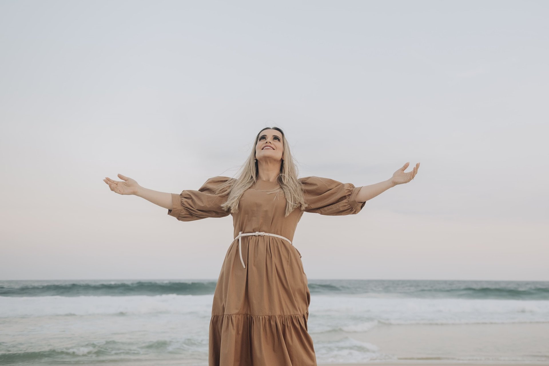 woman wearing yellow long-sleeved dress under white clouds and blue sky during daytime
