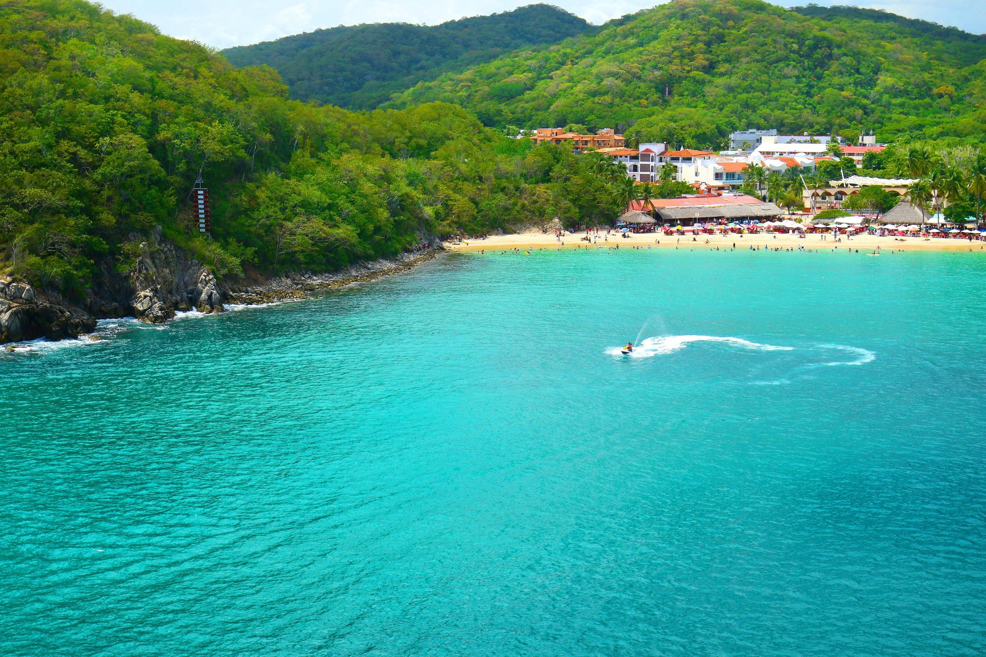 an aerial view of a beach with boats in the water