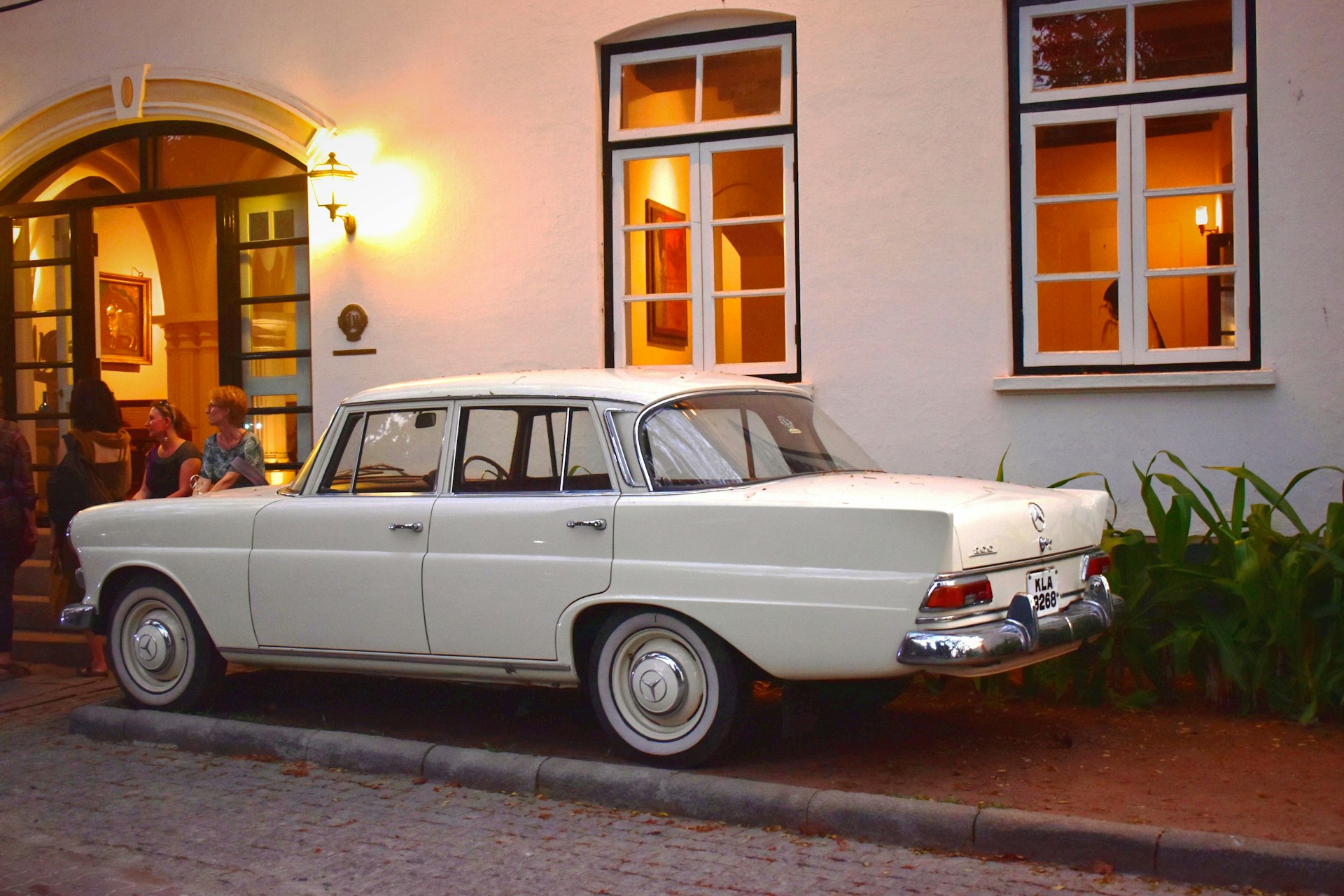 White vintage car parked outside a heritage hotel in Fort Kochi, Kerala.