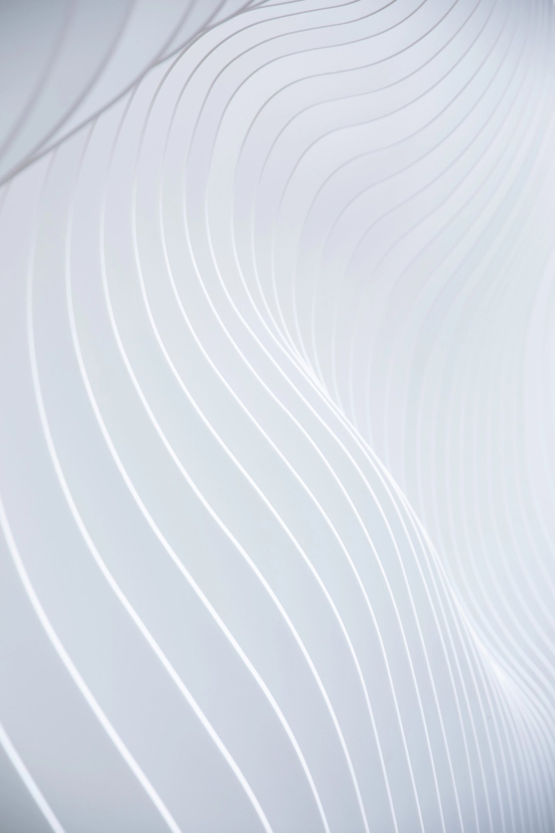 an abstract photo of a curved building with a blue sky in the background