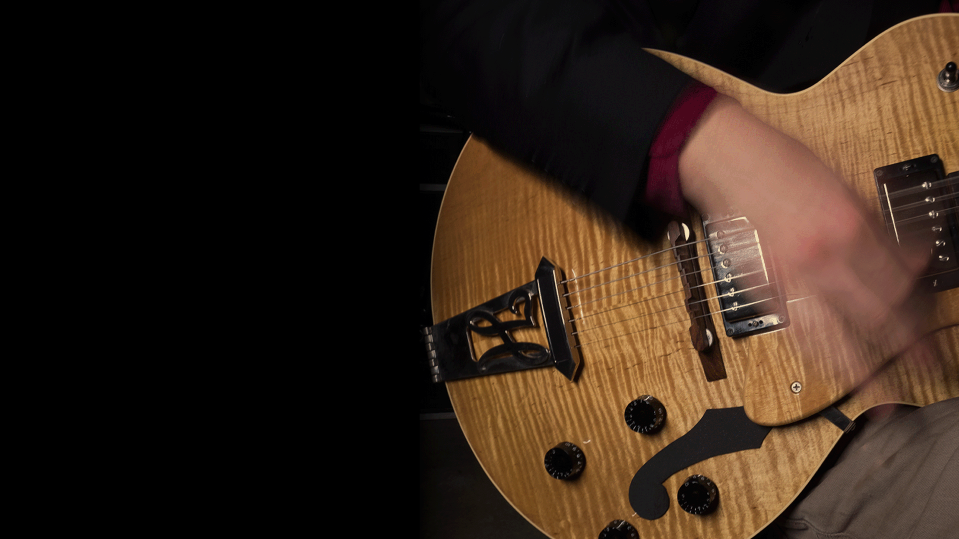 a hand rapidly strumming a guitar