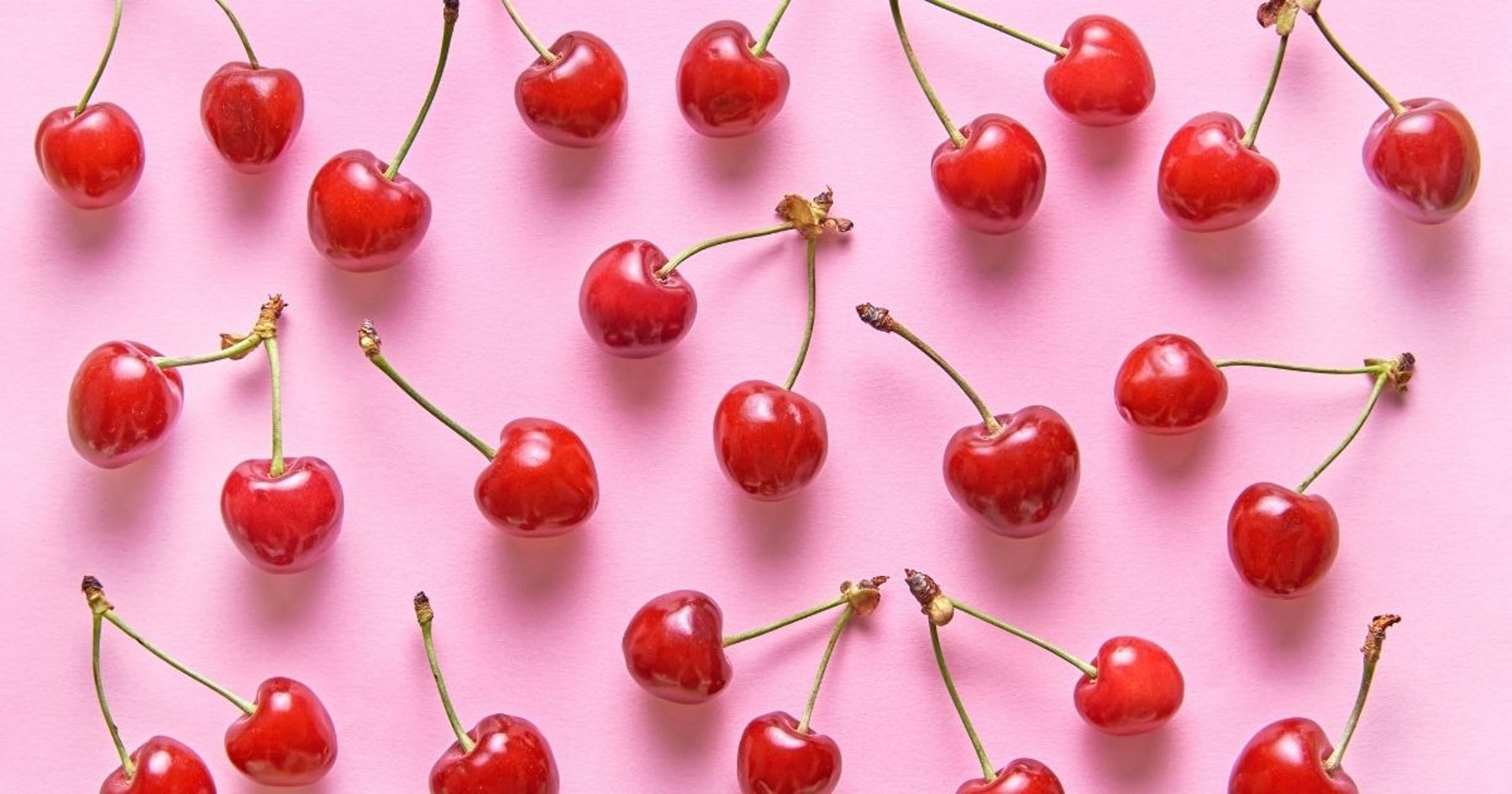 pomegranates and oranges on a pink surface