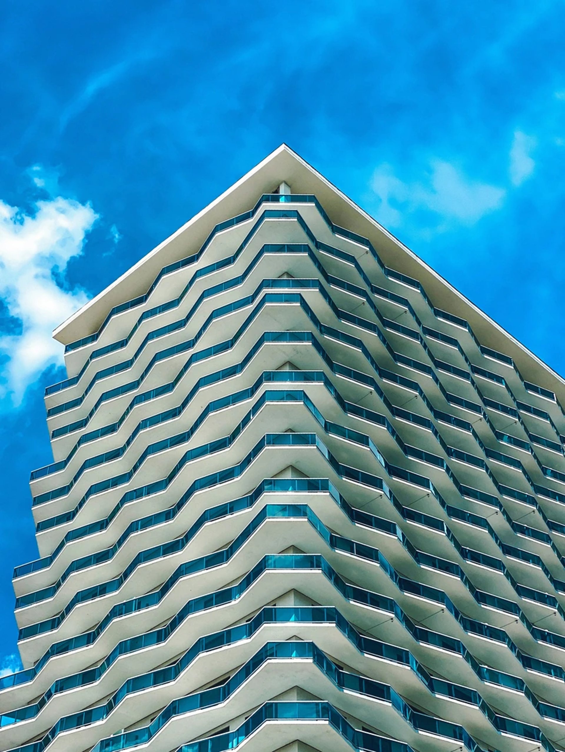 an abstract photo of a curved building with a blue sky in the background
