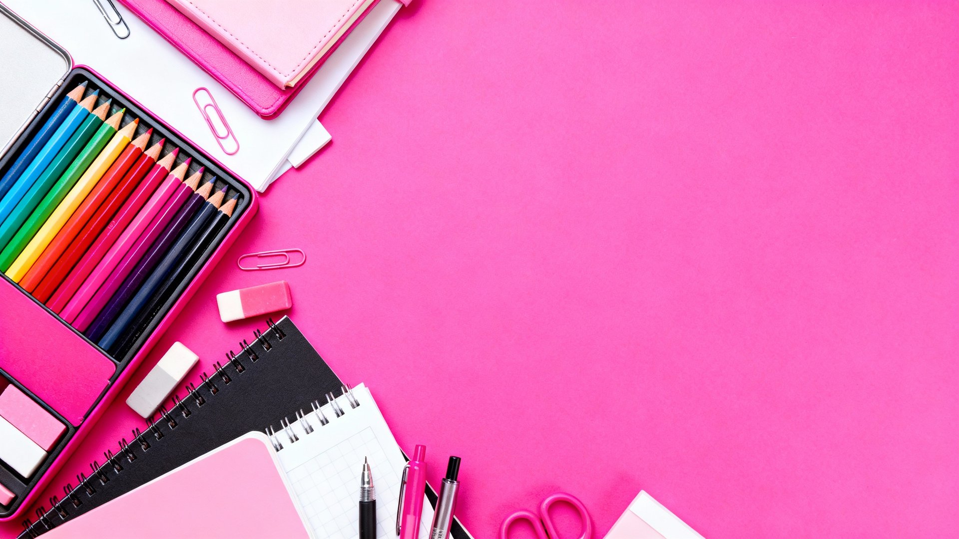 a desk with a notebook, pens, and a box of cards
