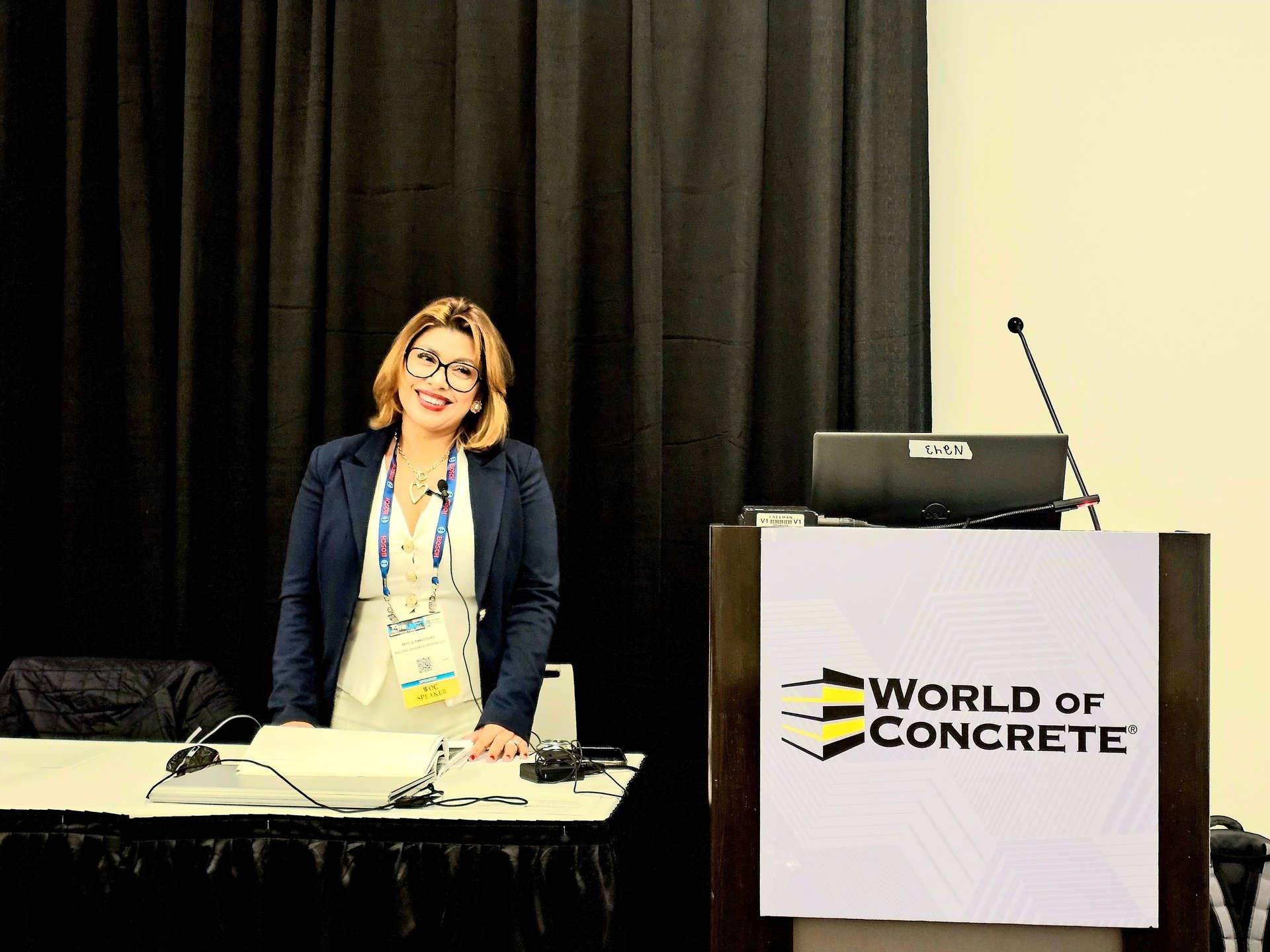 woman making speech in front of people sitting on individual chairs