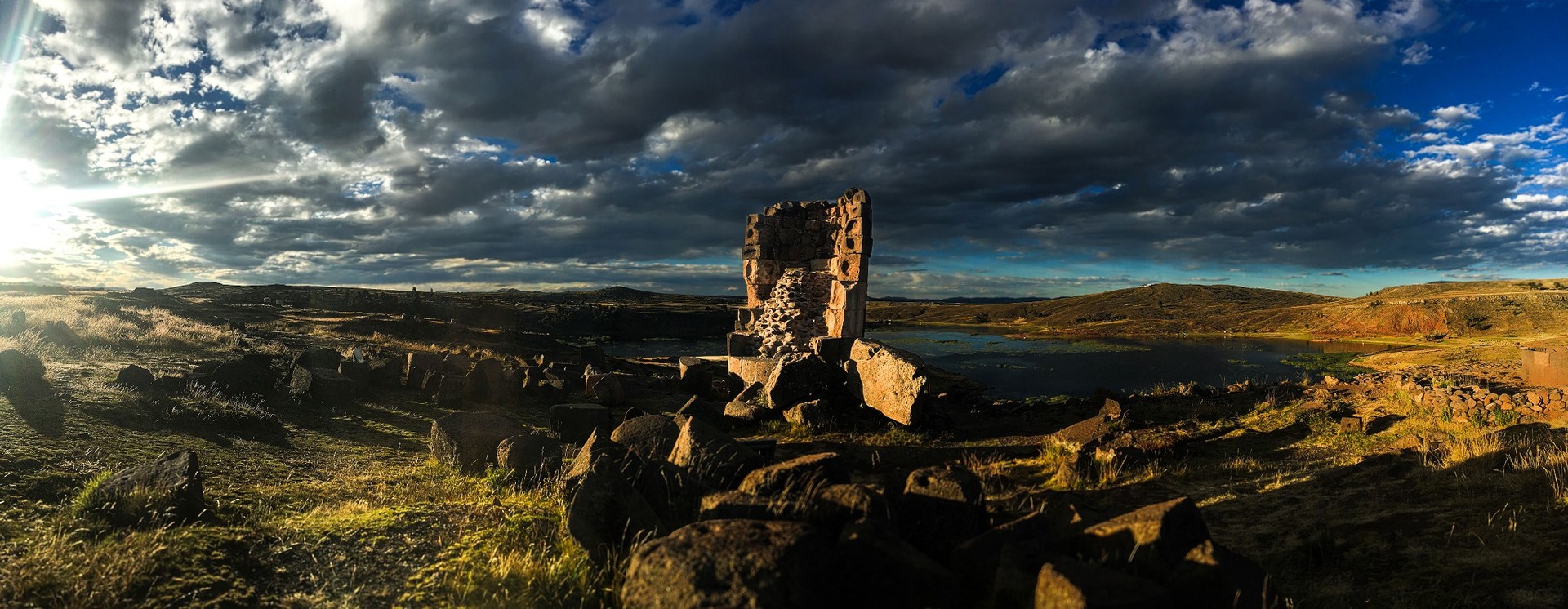 Sillustani au bord du lac Umayo sous la lumière dorée de fin de journée révélant les ruines andines anciennes dans la vallée