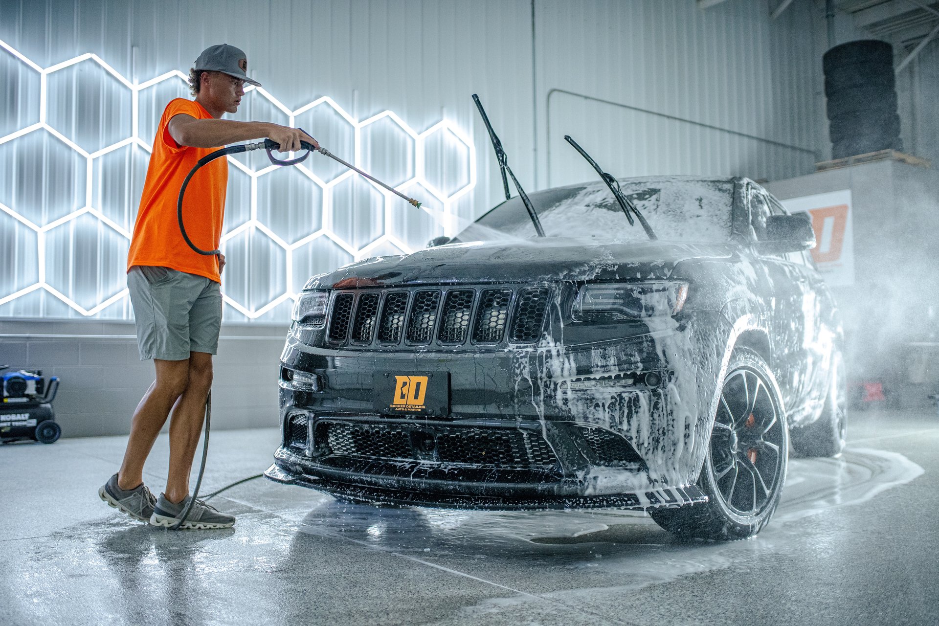 A person cleaning a car with a yellow cloth