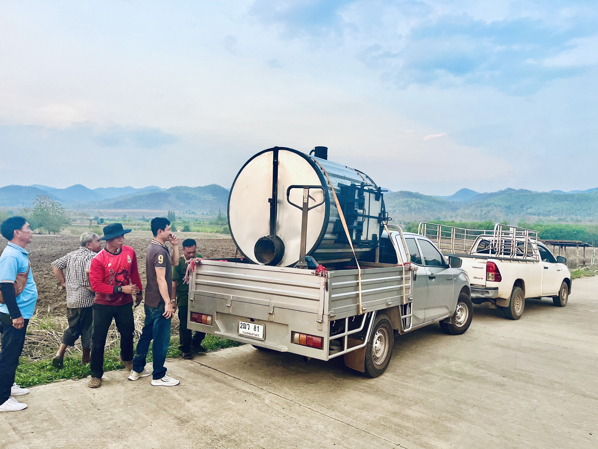 man in blue jacket standing beside brown wooden post