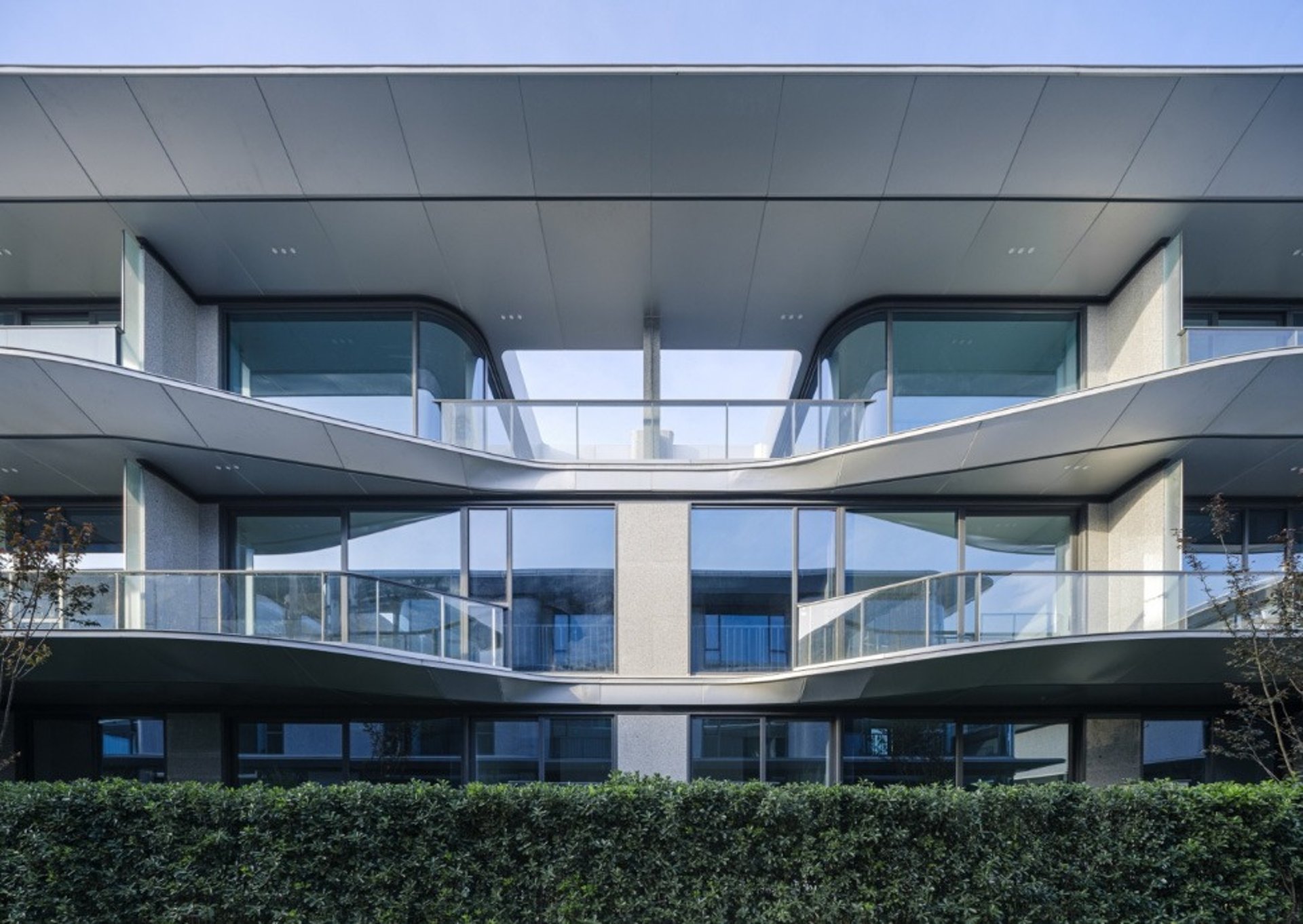 an abstract photo of a curved building with a blue sky in the background