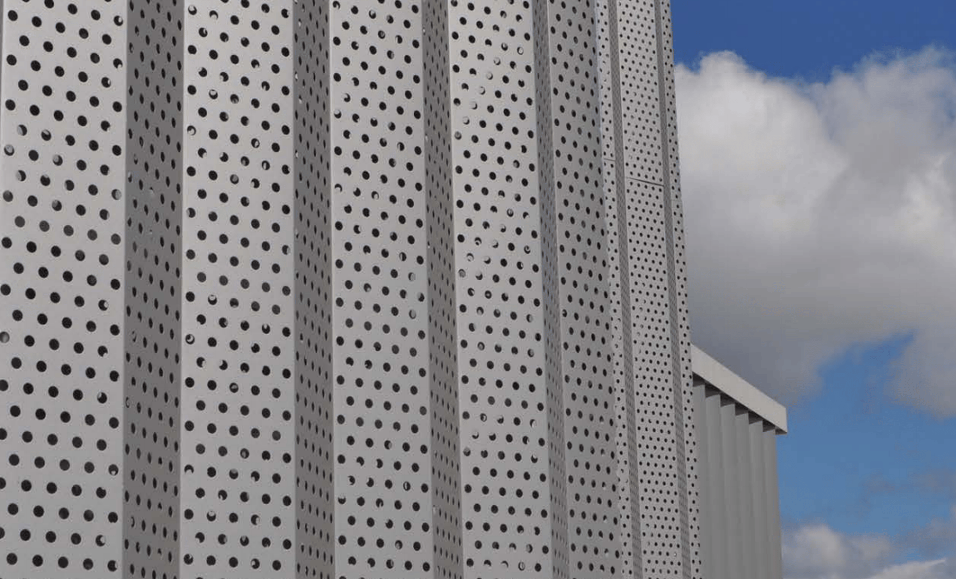 an abstract photo of a curved building with a blue sky in the background