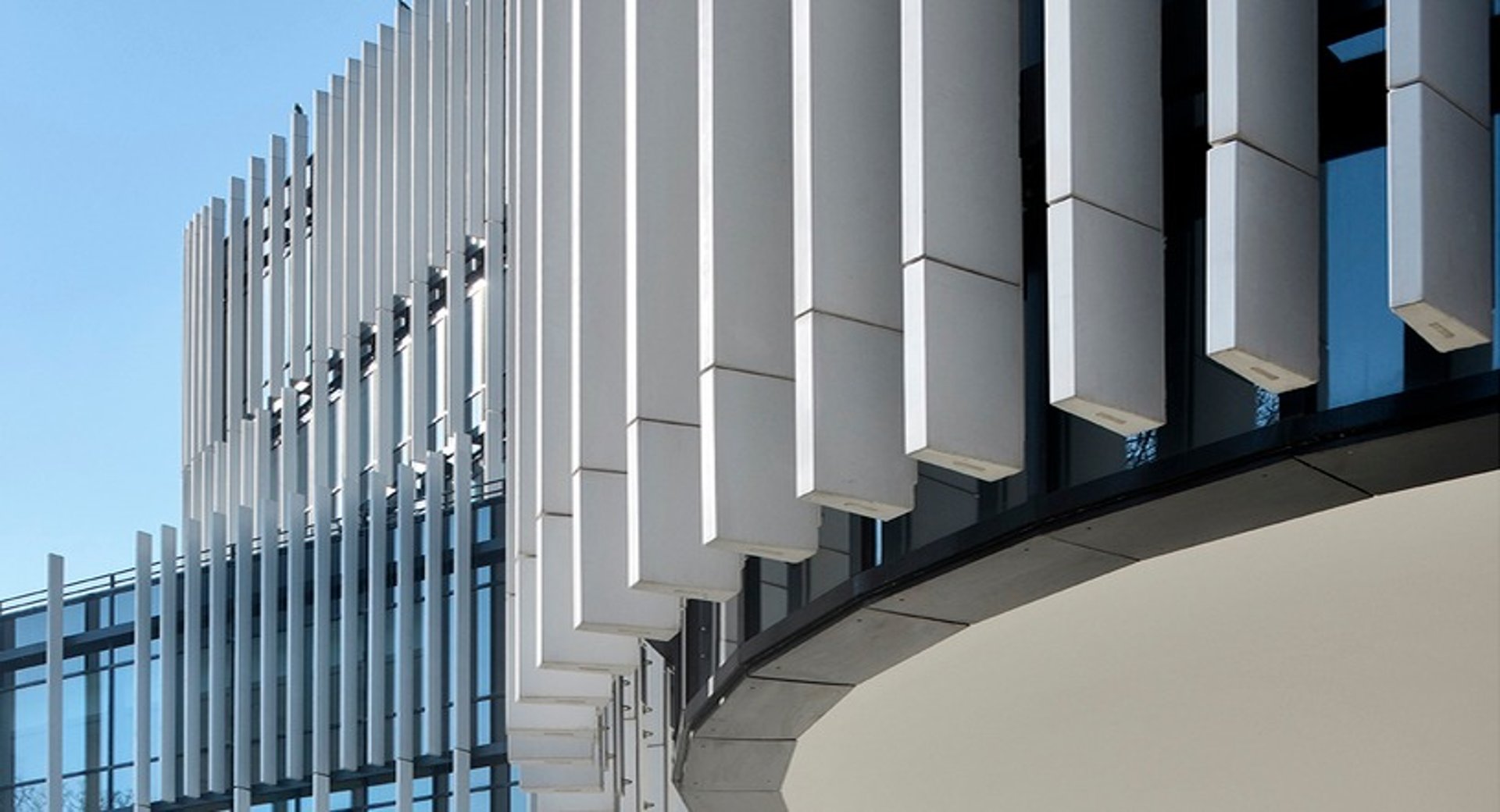 an abstract photo of a curved building with a blue sky in the background