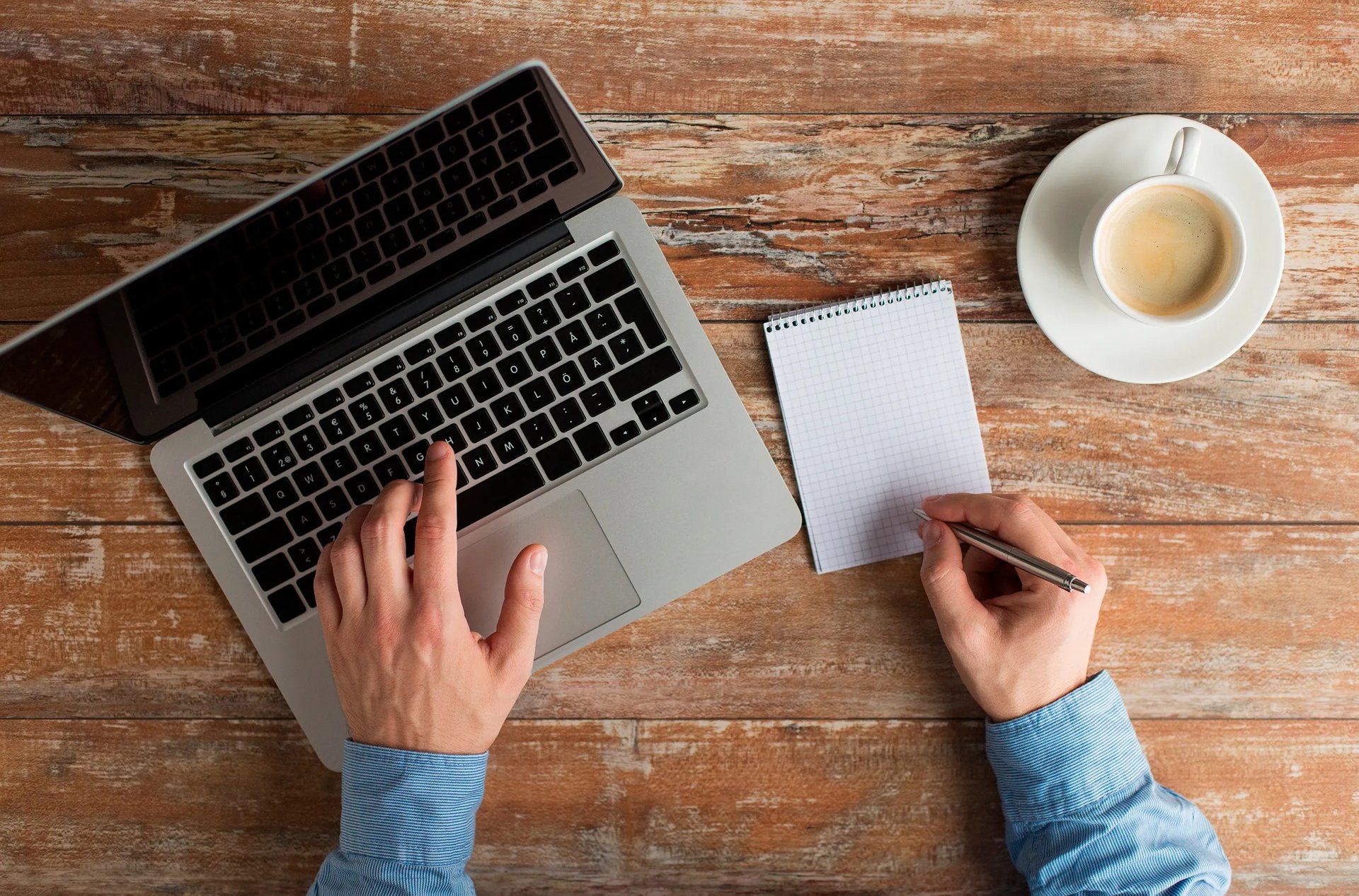 white laptop computer turned on beside brown paper cup