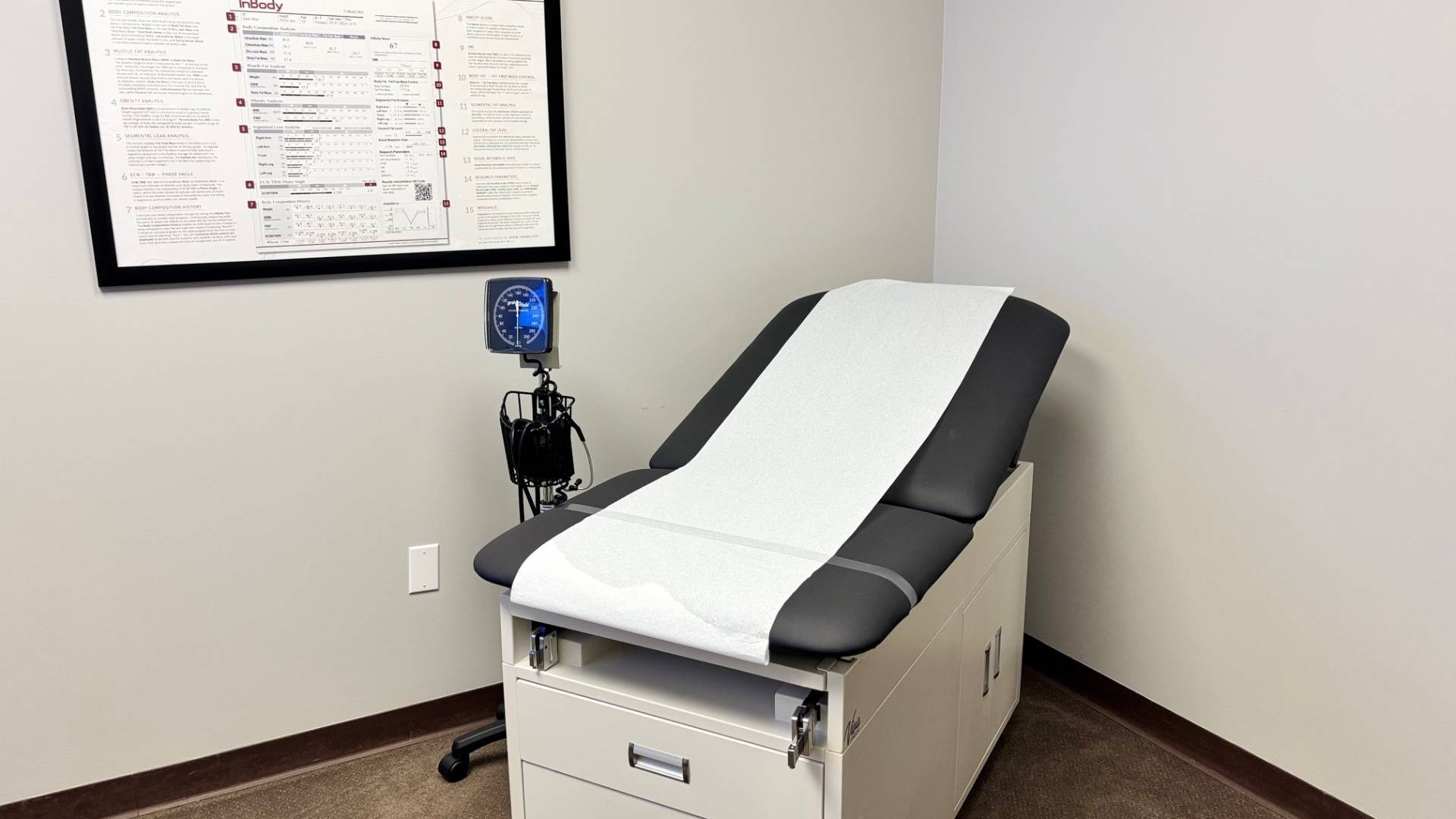 exam bed with chart on the wall and blood pressure machine next to bed