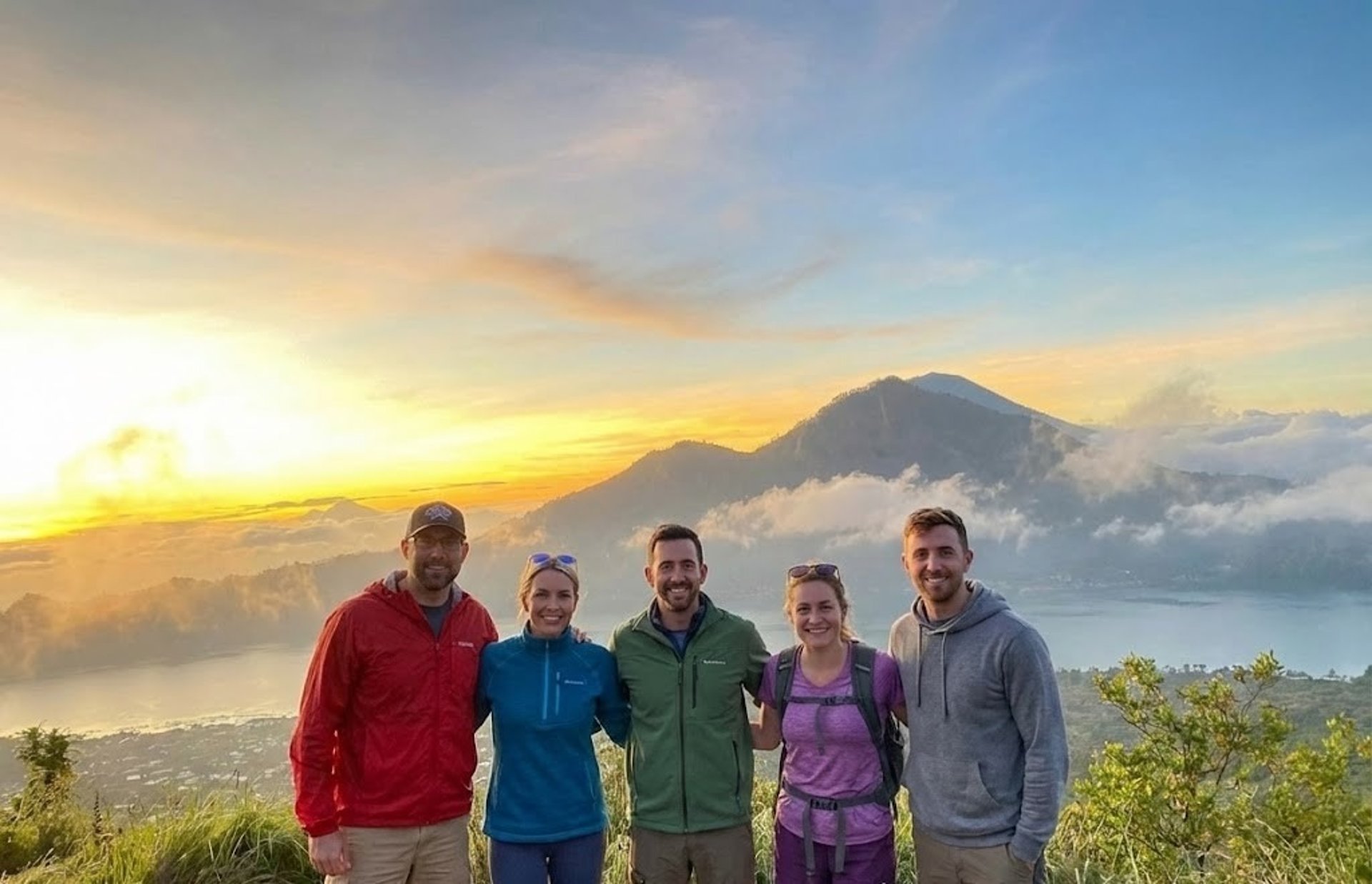 man squatting on mountain top during daytime