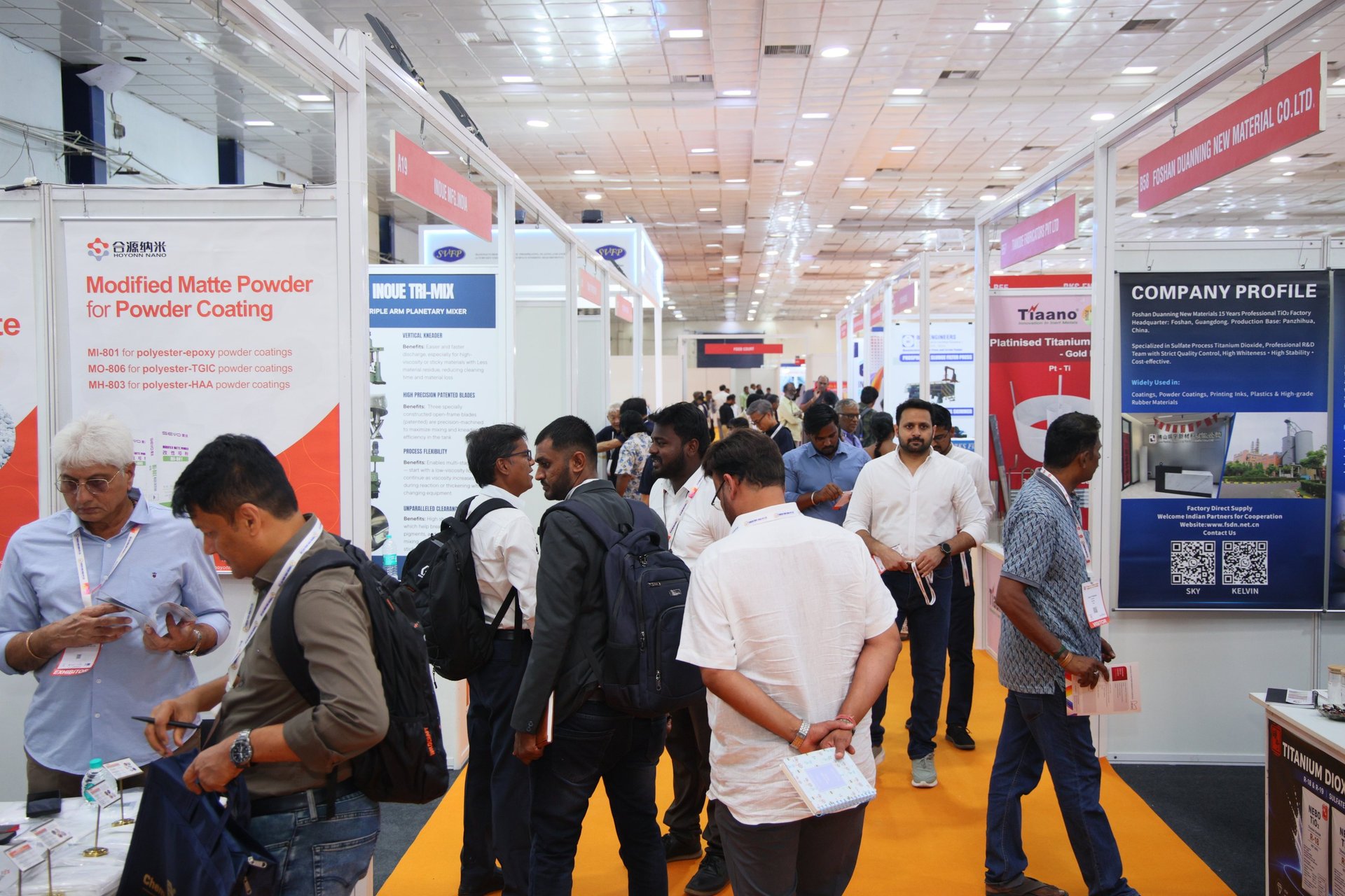 a red and white trade show booth with people standing around