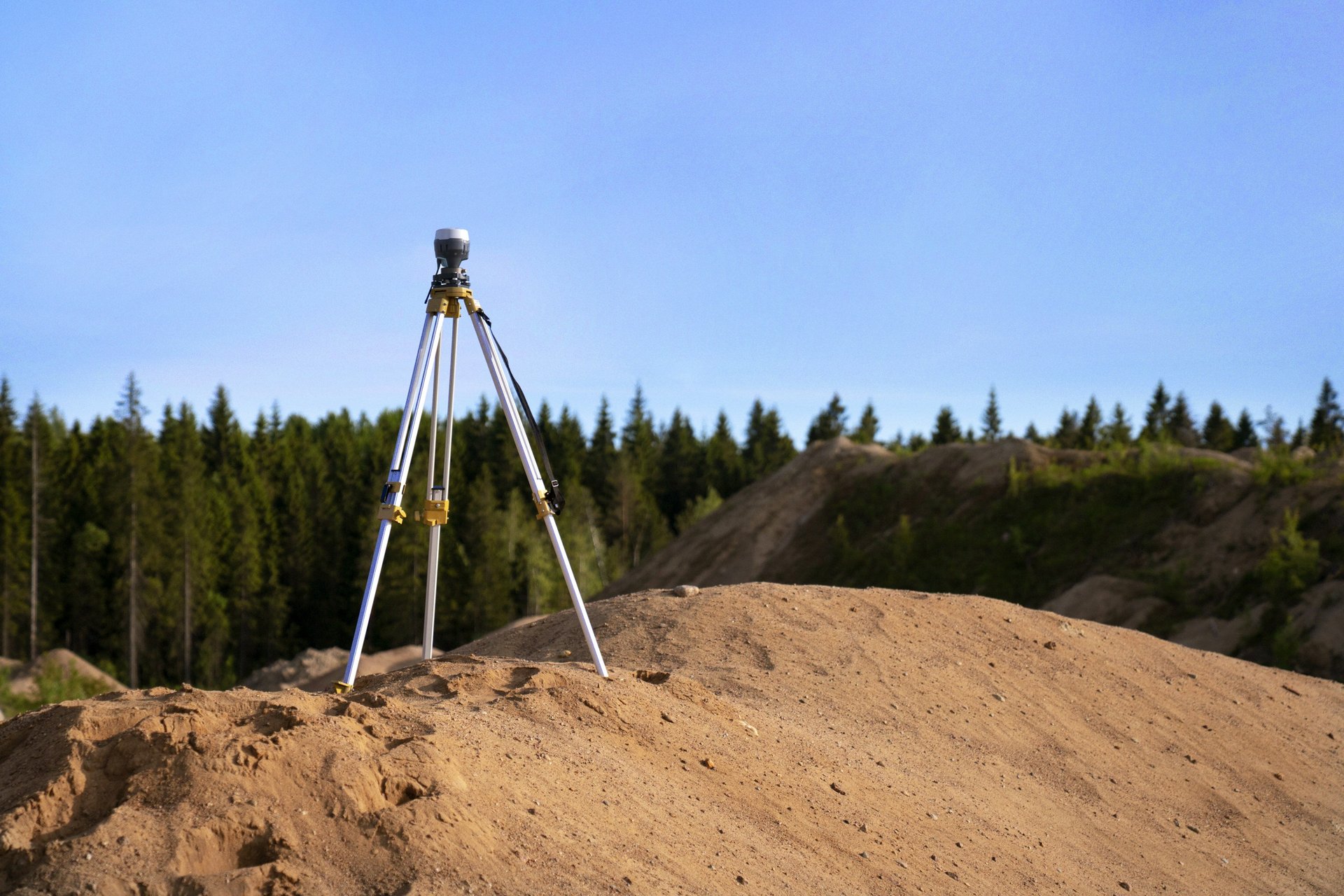 a man standing next to a yellow and black tripod