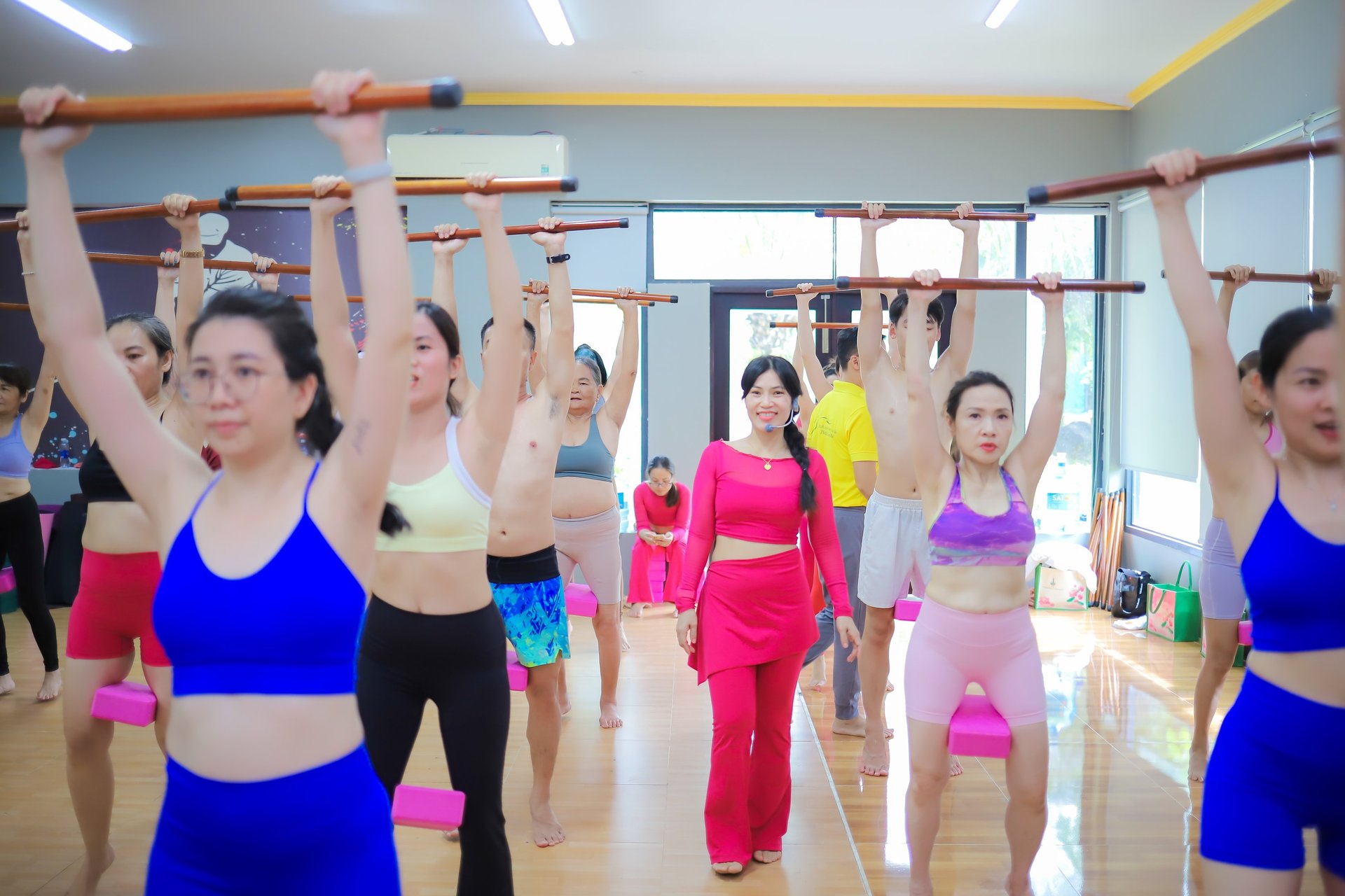 woman in white tank top and black leggings sitting on purple yoga mat