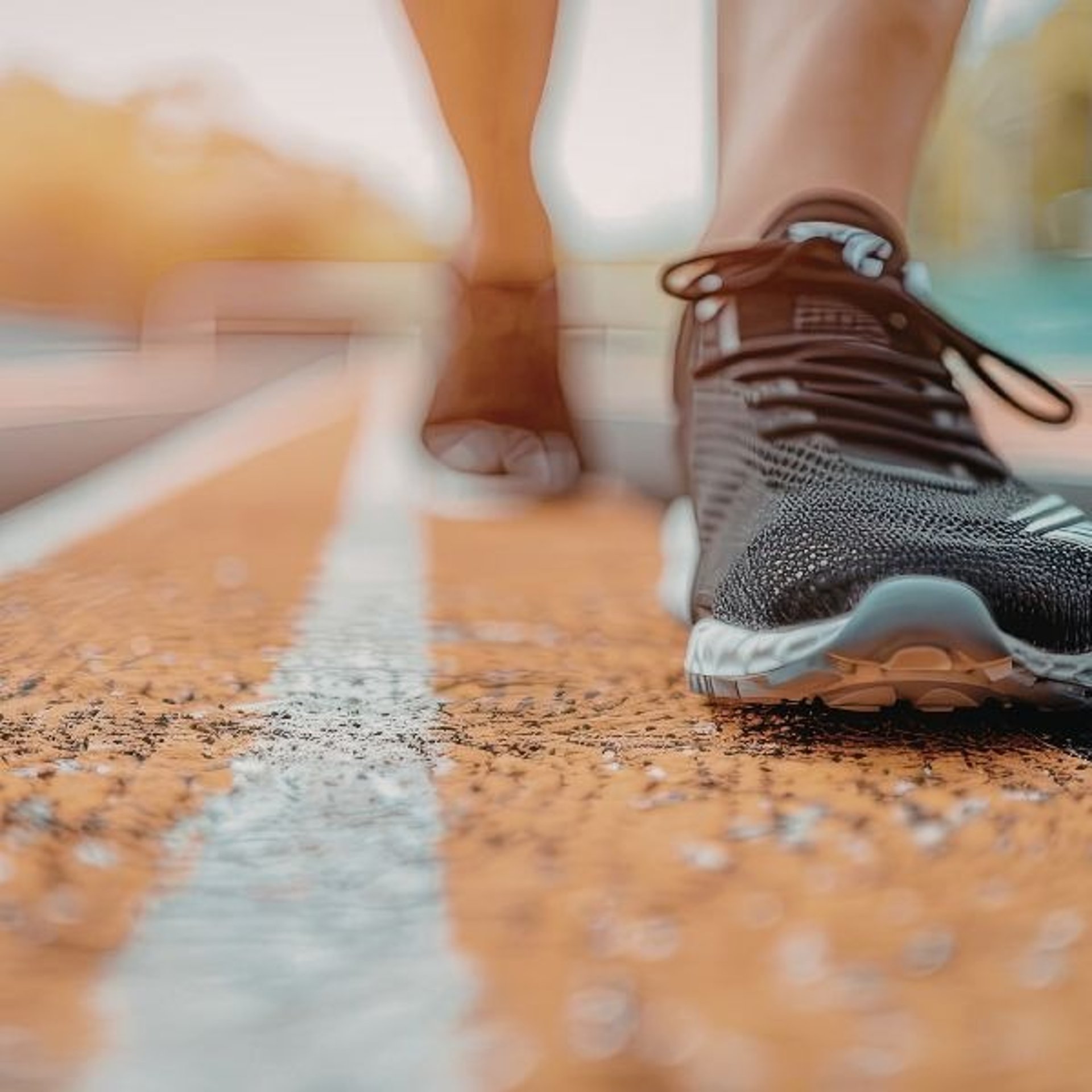 a woman drinking water while standing on a track