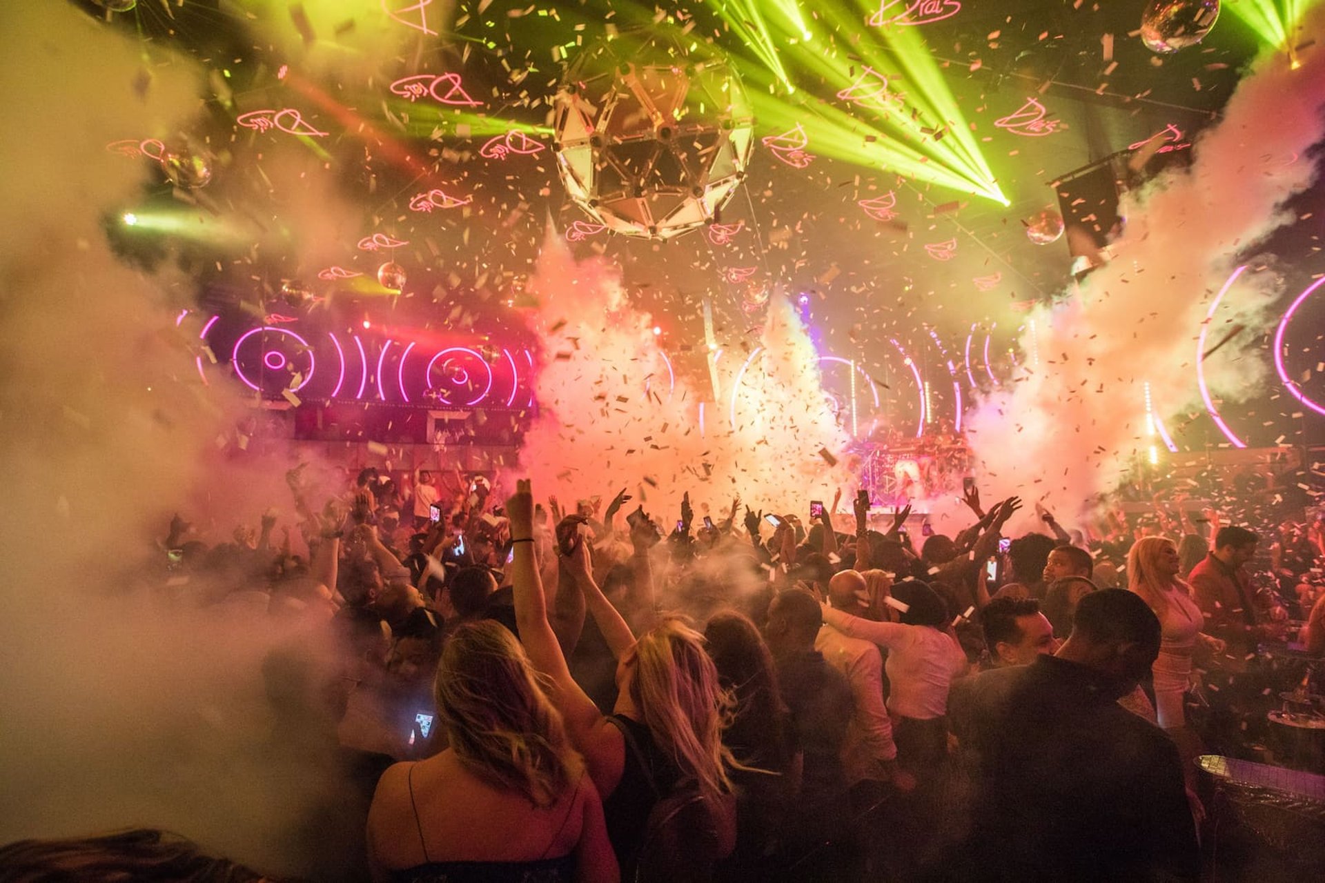 Las Vegas hip hop crawl crowd turning up inside packed hip hop nightclub with lights, confetti, and DJ energy.