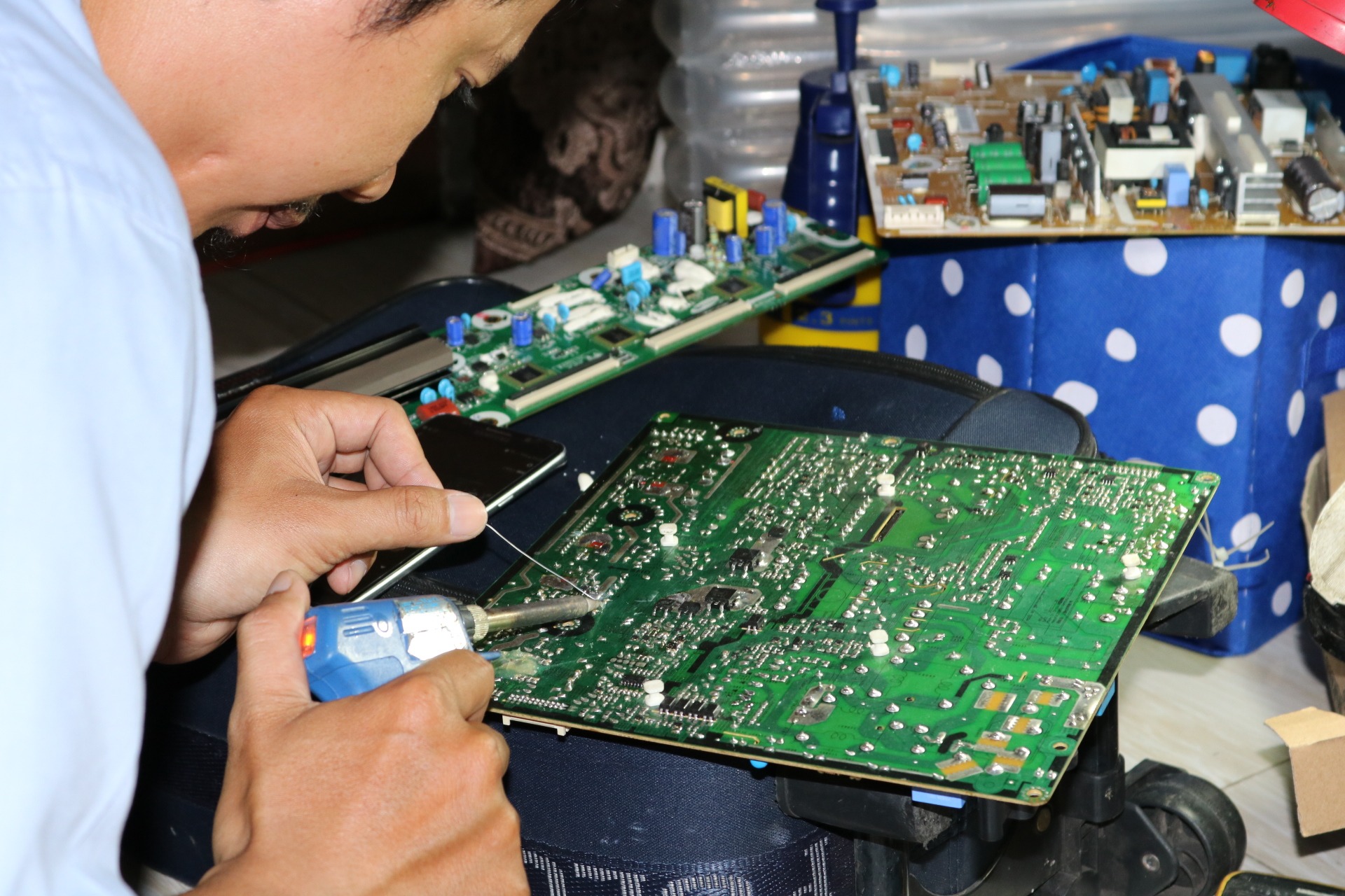 Person working on complex electronic circuitry with wires