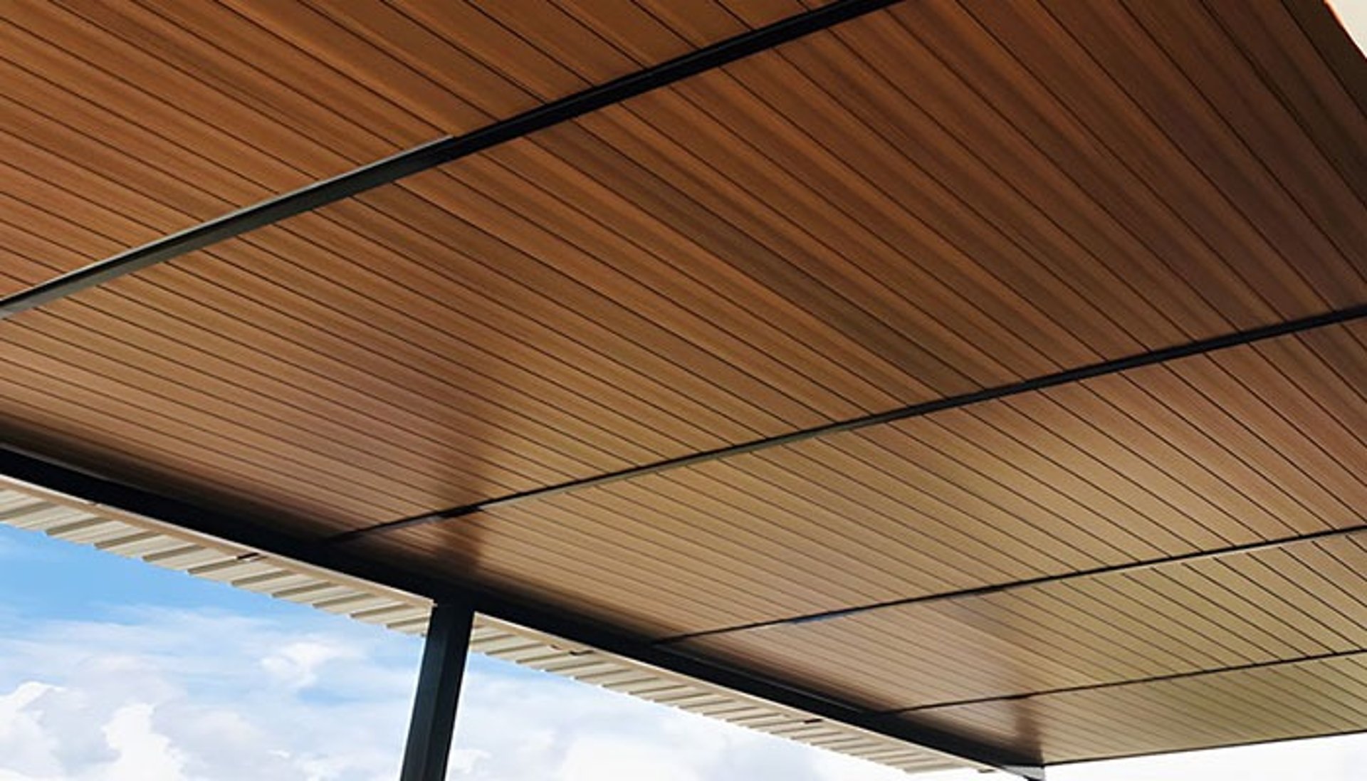 Recessed ceiling light fixture on a wood paneled ceiling.