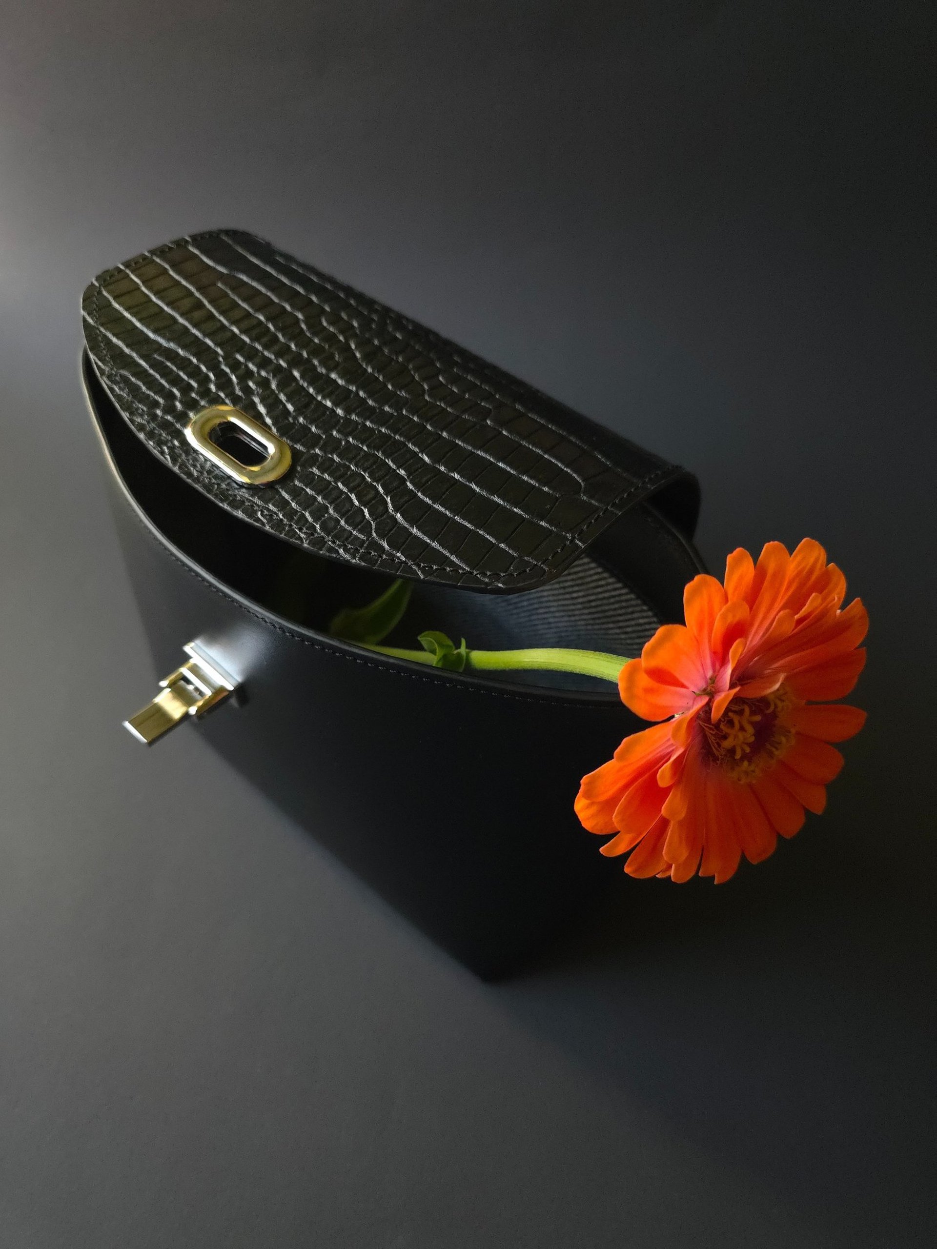 Black leather purse with a flap closure in crocodile print leather