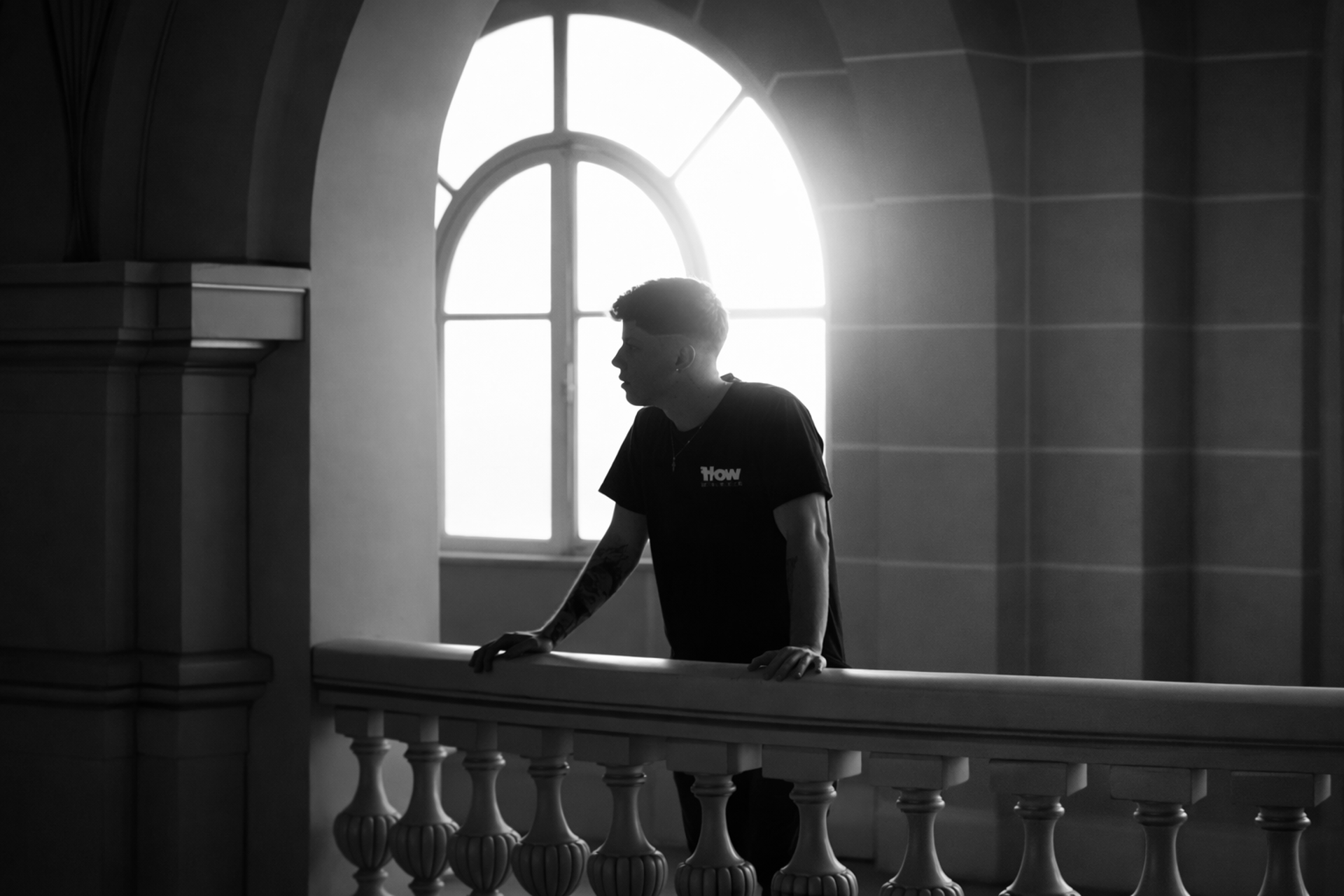 man in white shirt holding black video camera