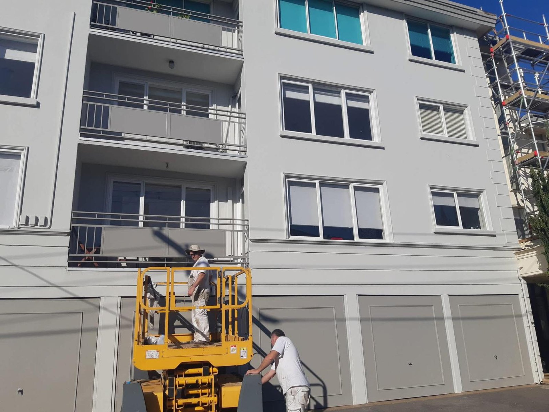 A painter is working on a building's exterior.