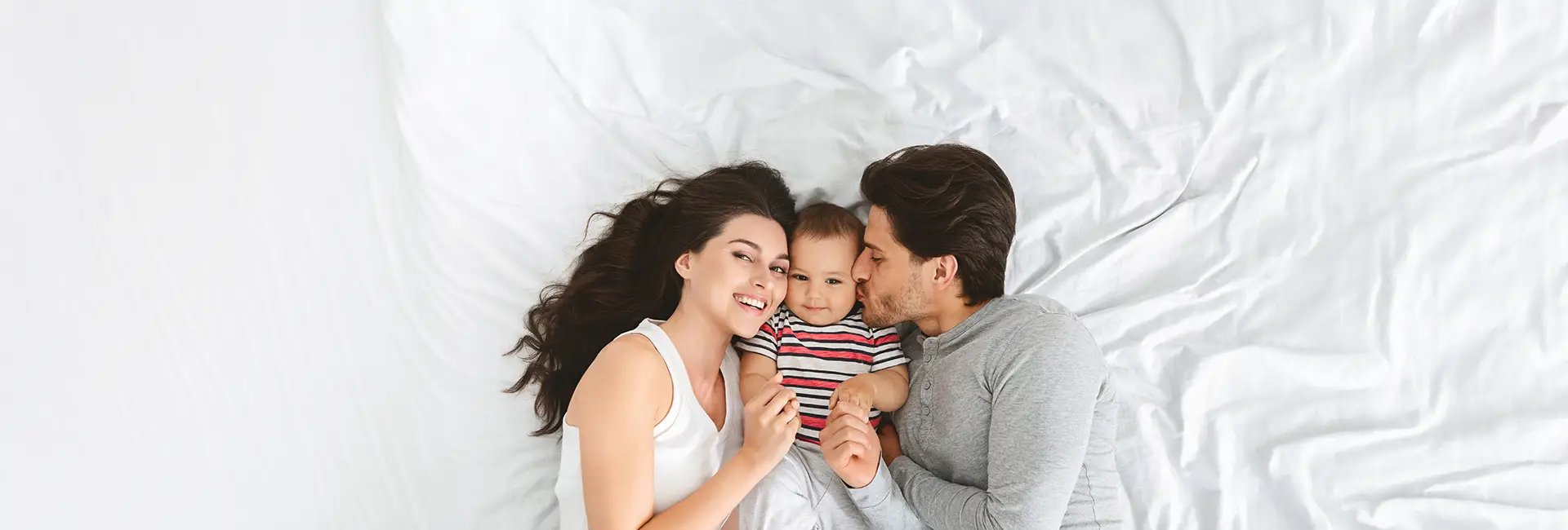 woman and baby sitting on white sofa