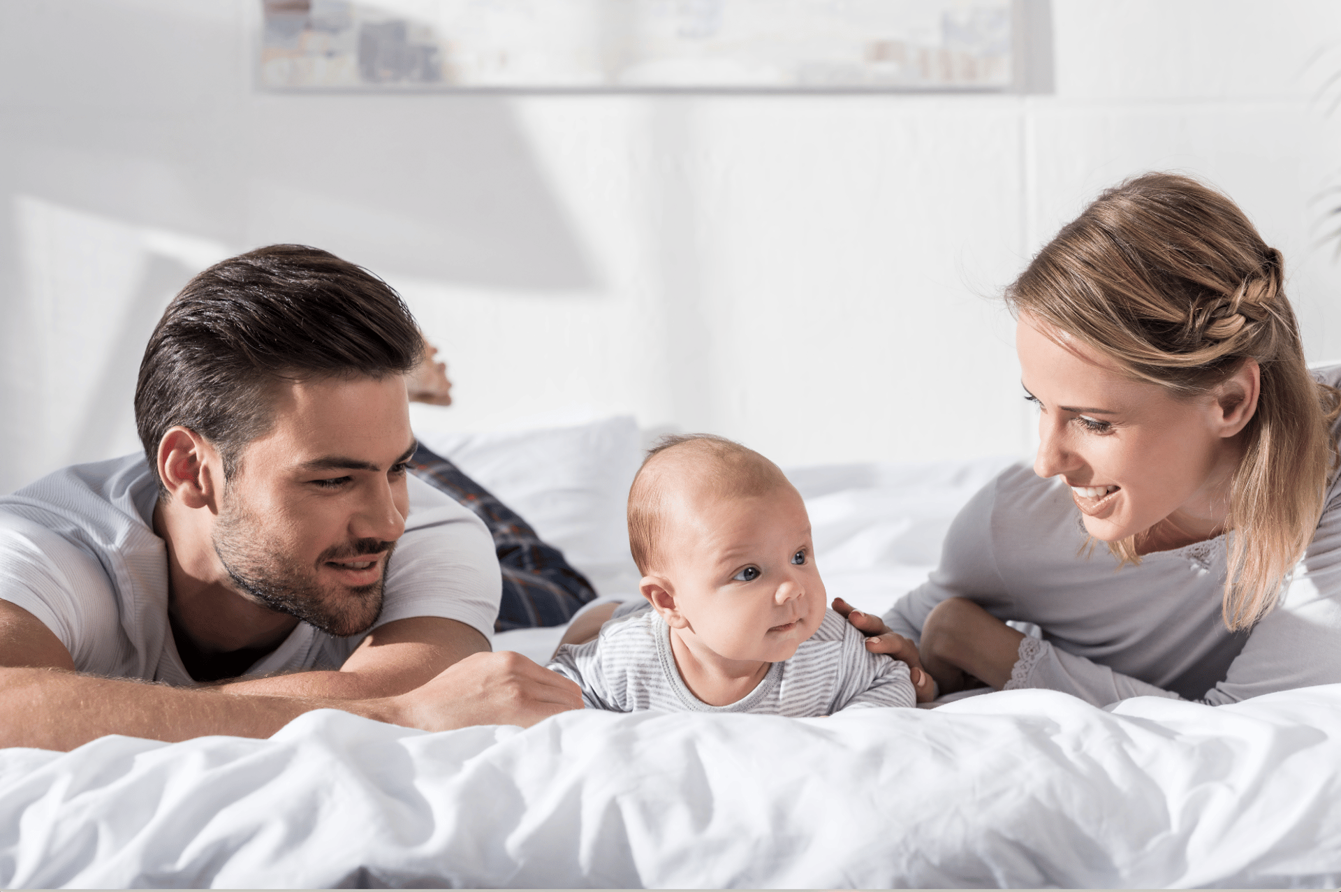 woman and baby sitting on white sofa